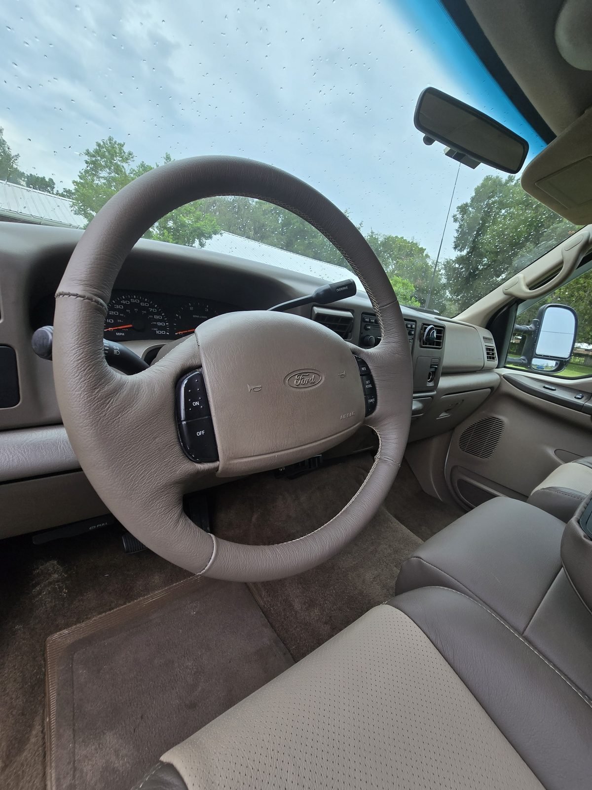Custom leather steering wheel wrap in the same truck, RJW's own custom work (not a Katzkin product).