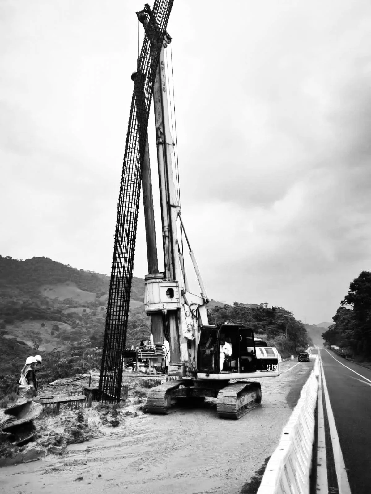 Maquinaria de construcción en una carretera de montaña en un día nublado.