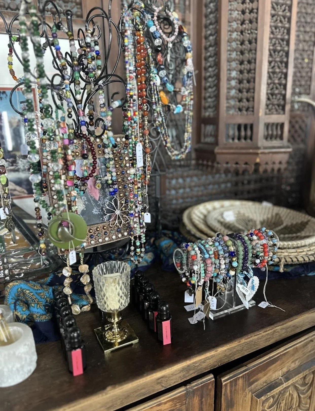 Display of colorful beaded necklaces and bracelets on a jewelry stand in a boutique store.