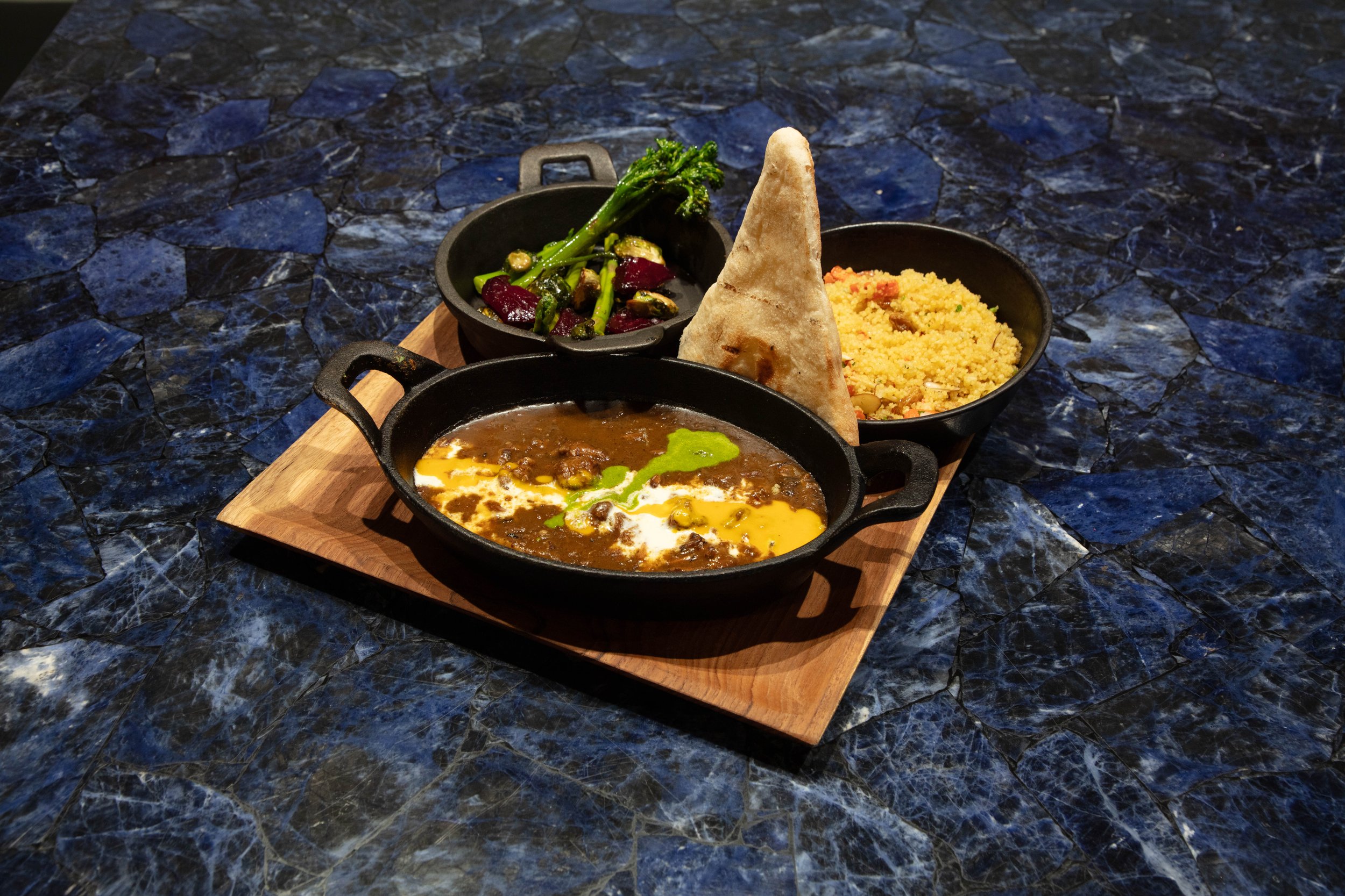 Moroccan Style Braised Curry Goat, Almond- Raisins - Candy Carrot CousCous, Sauteed Vegetables, Pita Bread 