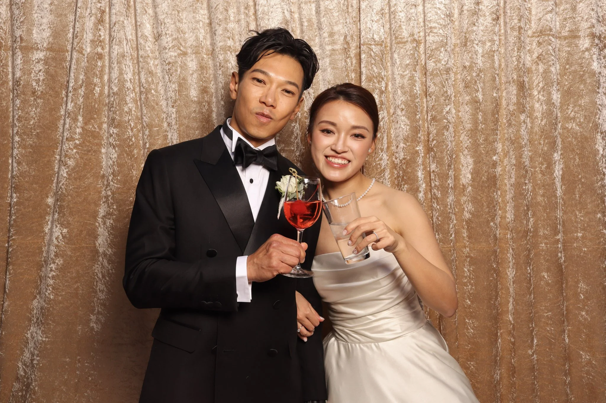 wedding couple posing in front of a champagne backdrop at a traditional chinese wedding 