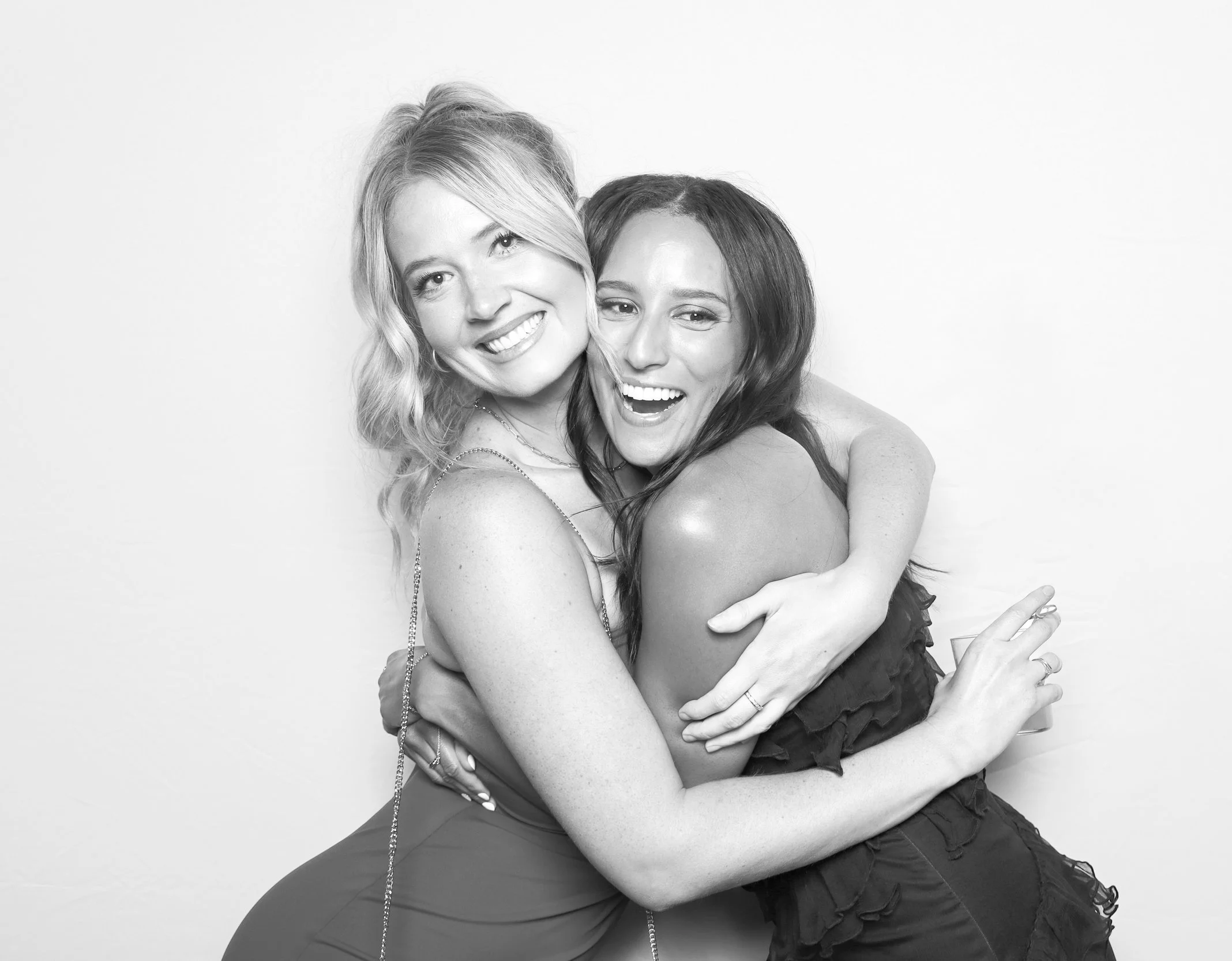 Laurie’s customers, Mariana and Carmen holding hands on a green lawn on their wedding day.