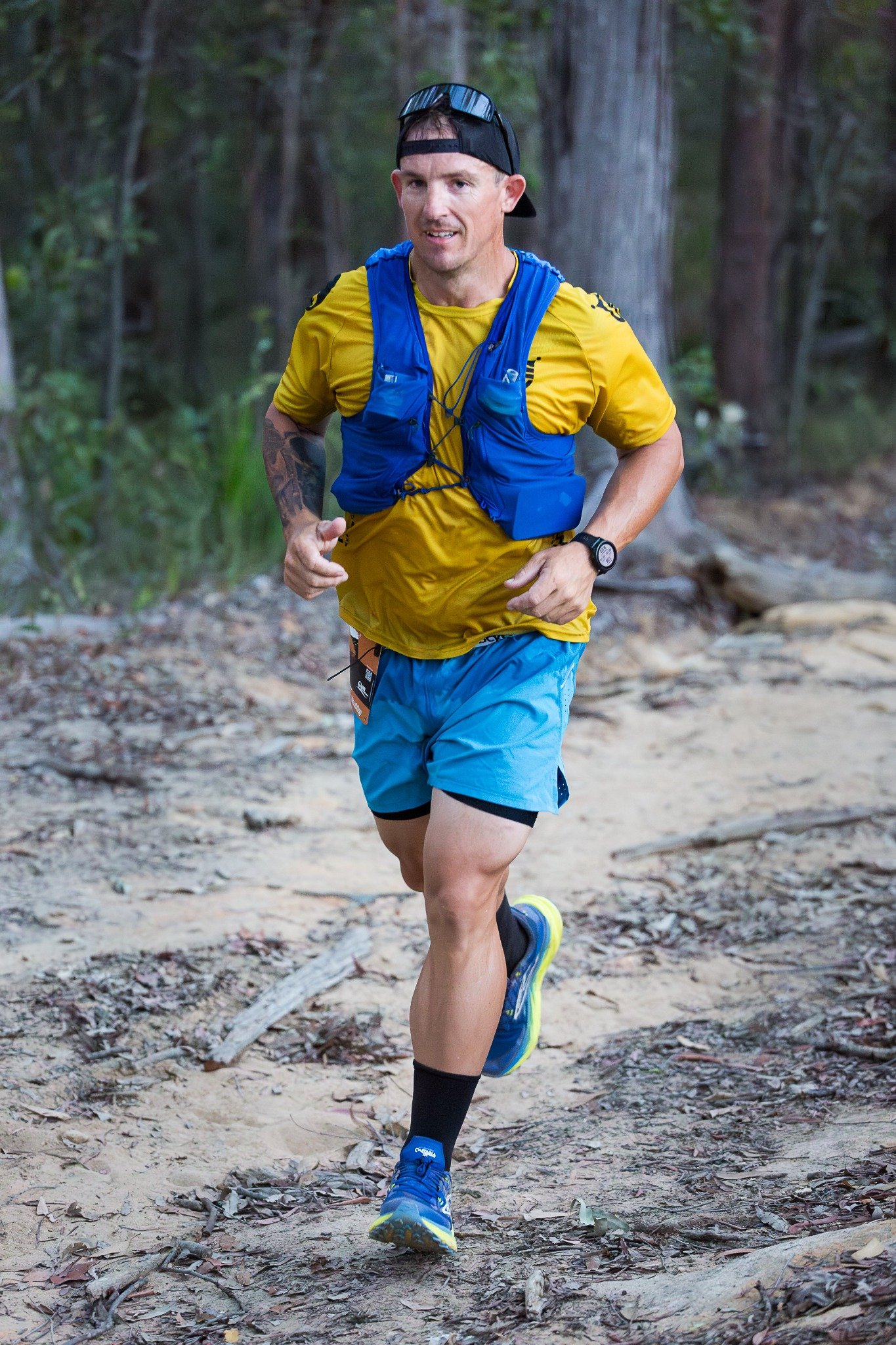 Matt running on a forest trail, smiling towards the camera