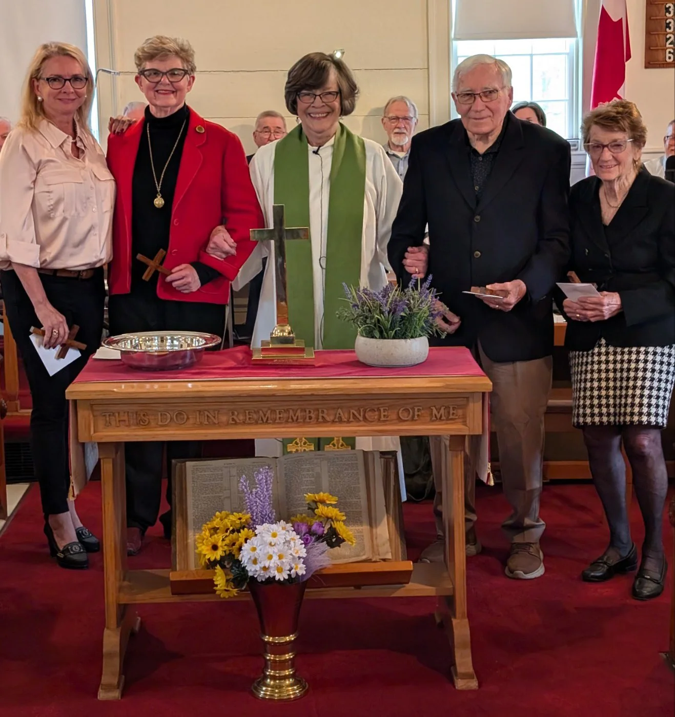 New members gather around the communion table with Reverend Sandra