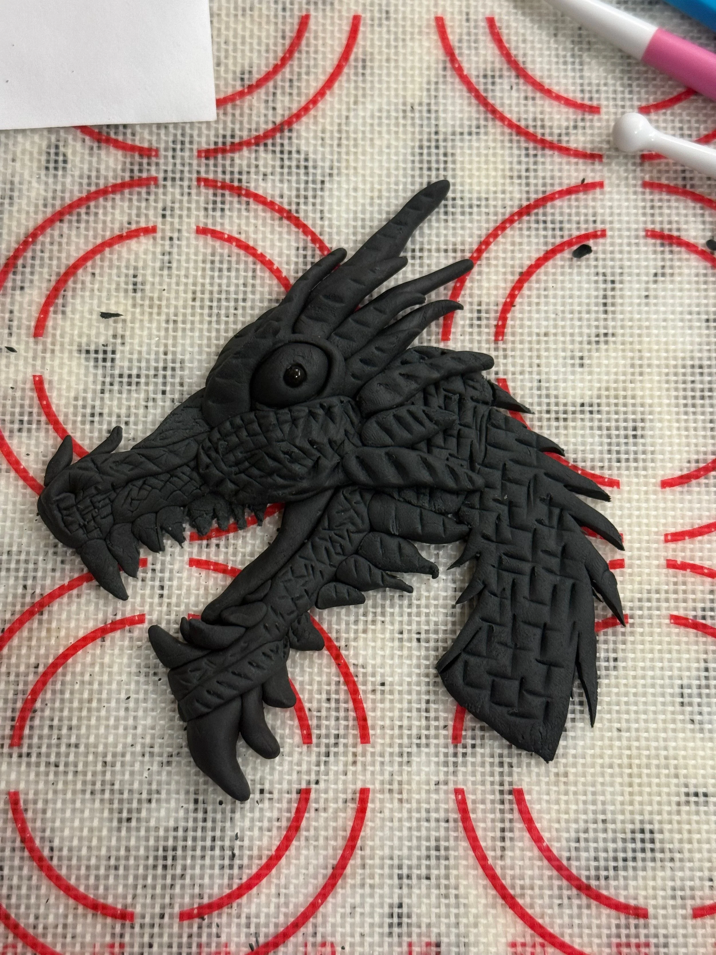 A black dragon sculpted from fondant.