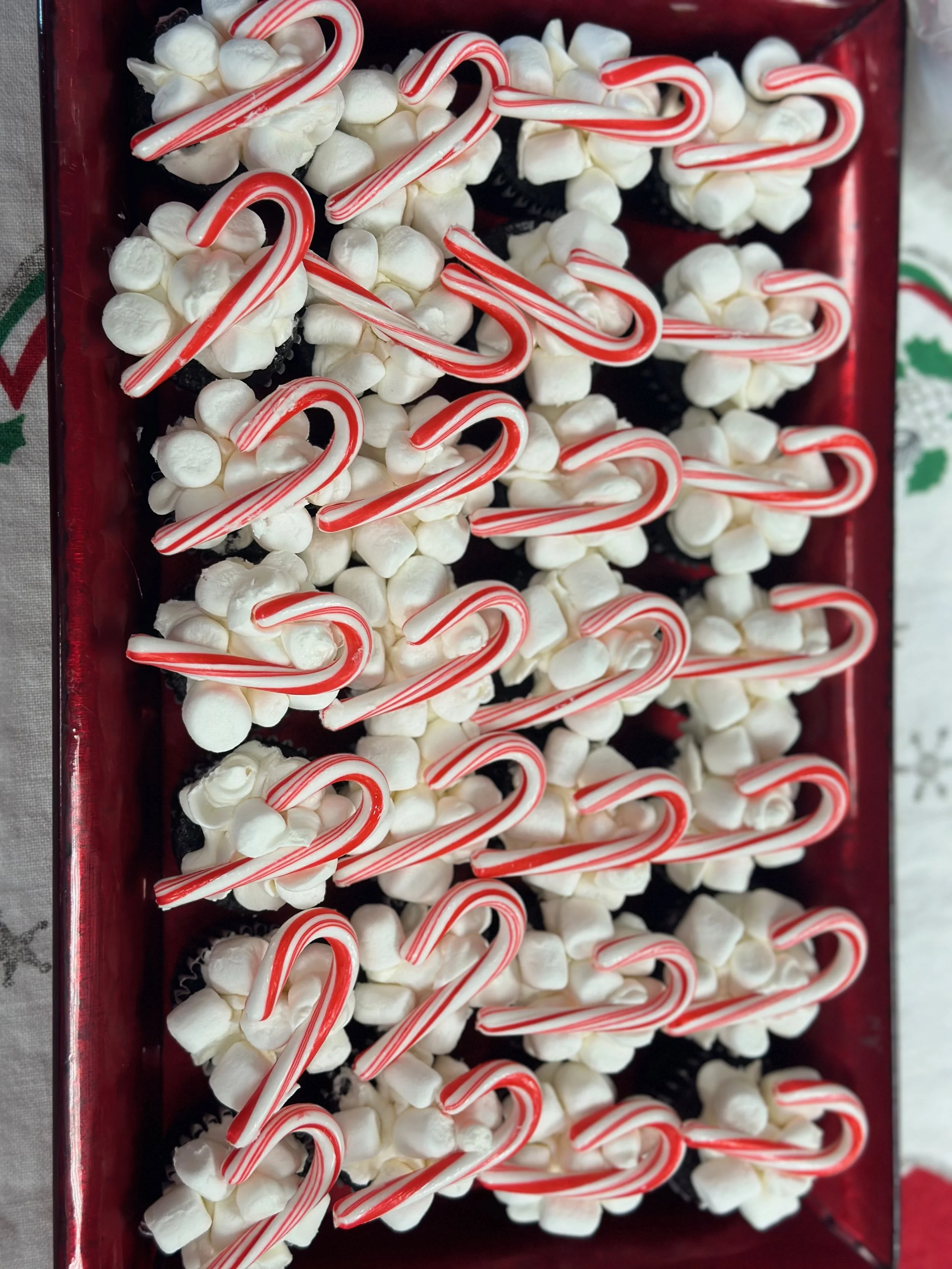 Candy canes and mini marshmallows in a red container, likely for holiday decoration or treats.