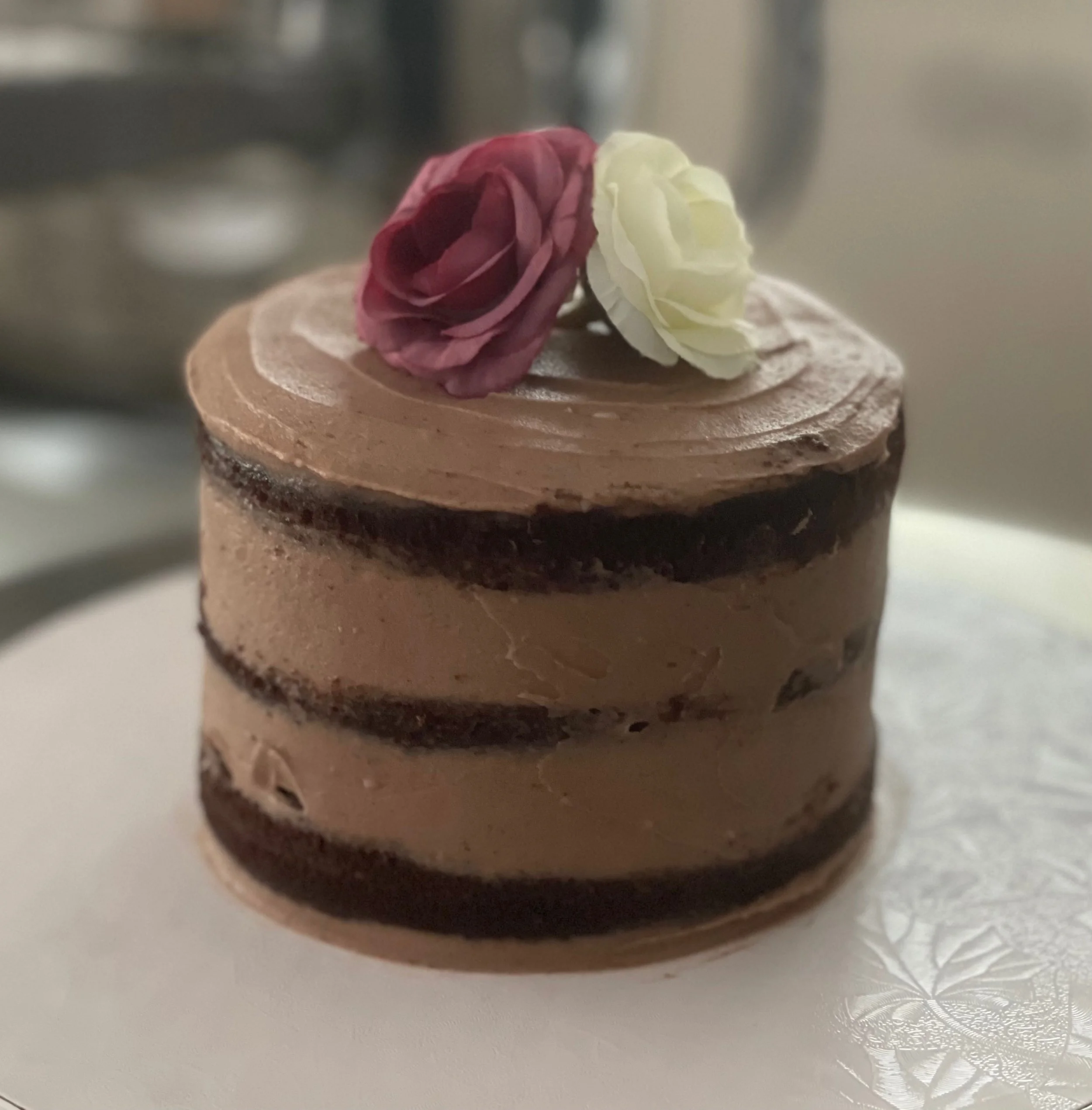 Chocolate mini-cake topped with pink and white silk roses.
