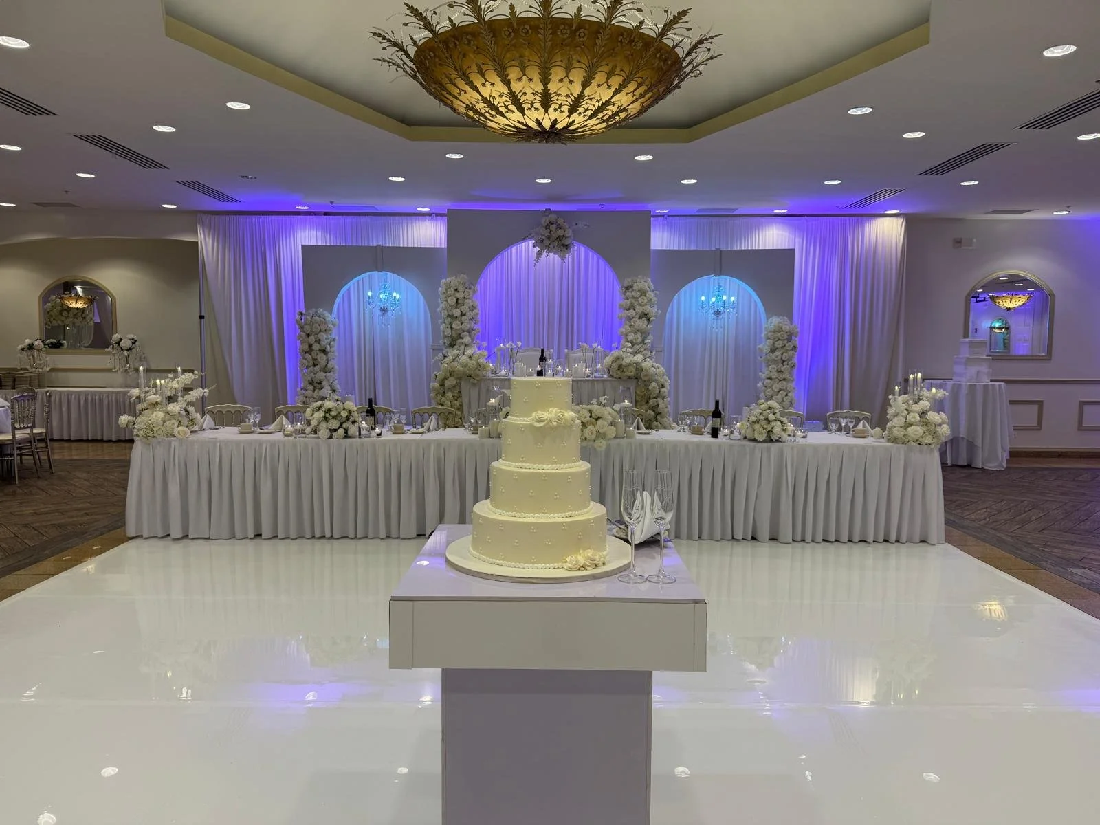 Our banquet hall event space decorated for a wedding with cake, flowers, and a table for the bride and groom