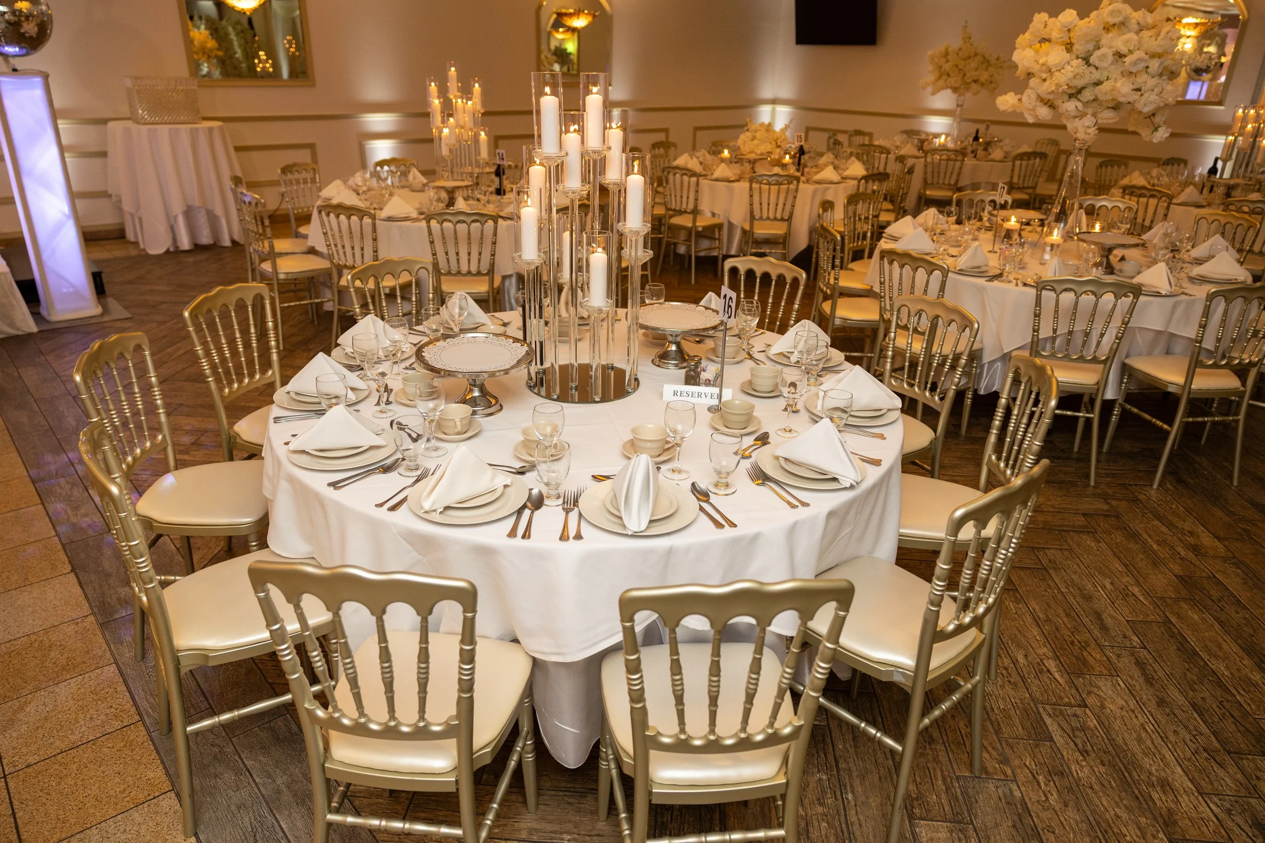 A table in the event space at Crystal Palace Banquets,set for dinner at a wedding, event, or party. It is a fully set table with napkins and silverware for multiple courses.