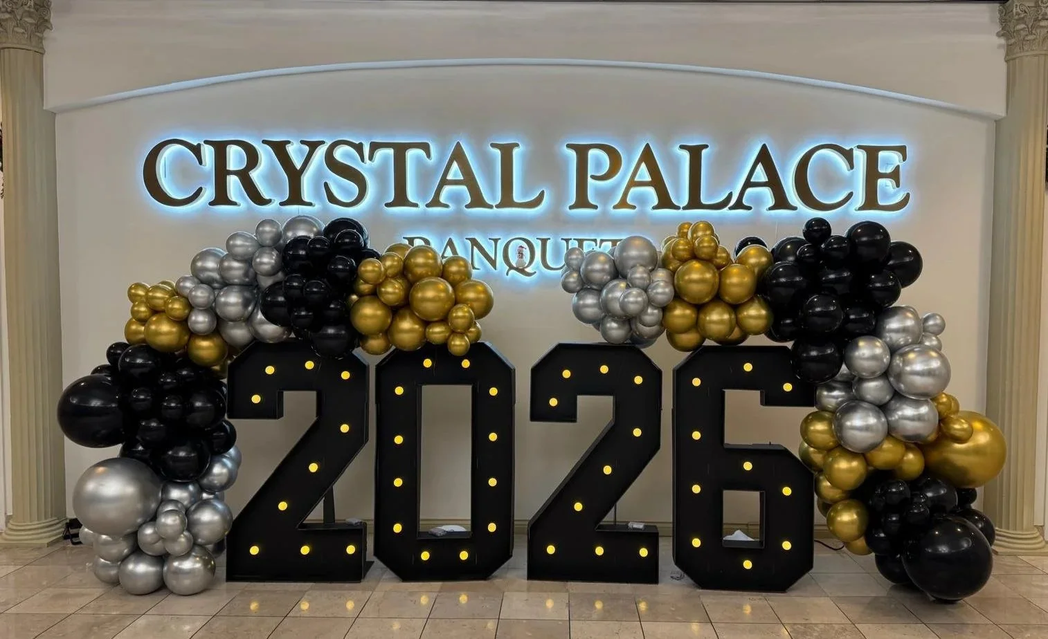 Crystal Palace Banquets decorated for a New Years Party Celebration. Balloons and lighting and a large 2026 in front of the event space doors.