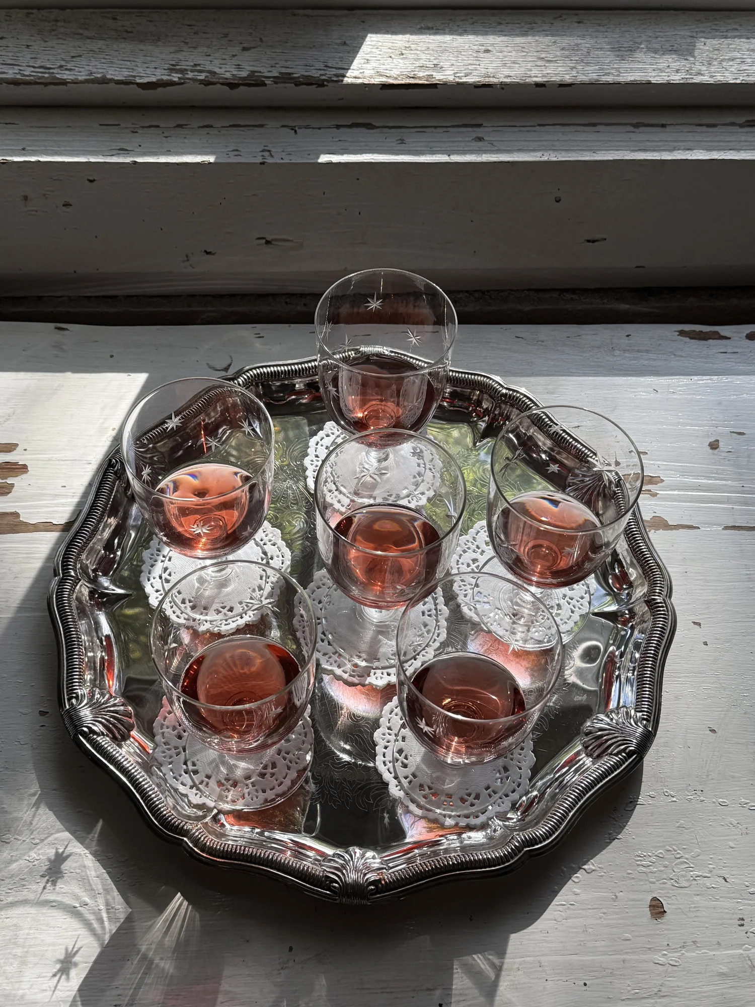 Round silver shell tray with six etched wine glasses