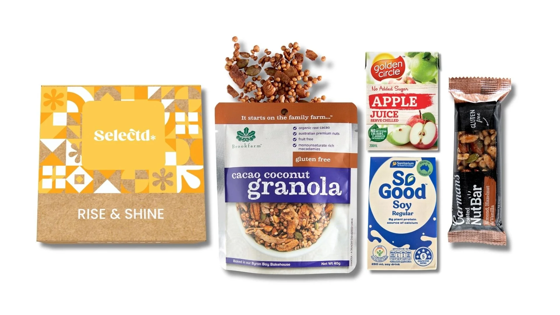 Collection of health foods including a box labeled 'Rise & Shine,' a bag of cacao coconut granola, a carton of apple juice, a soy drink, and a nut bar.