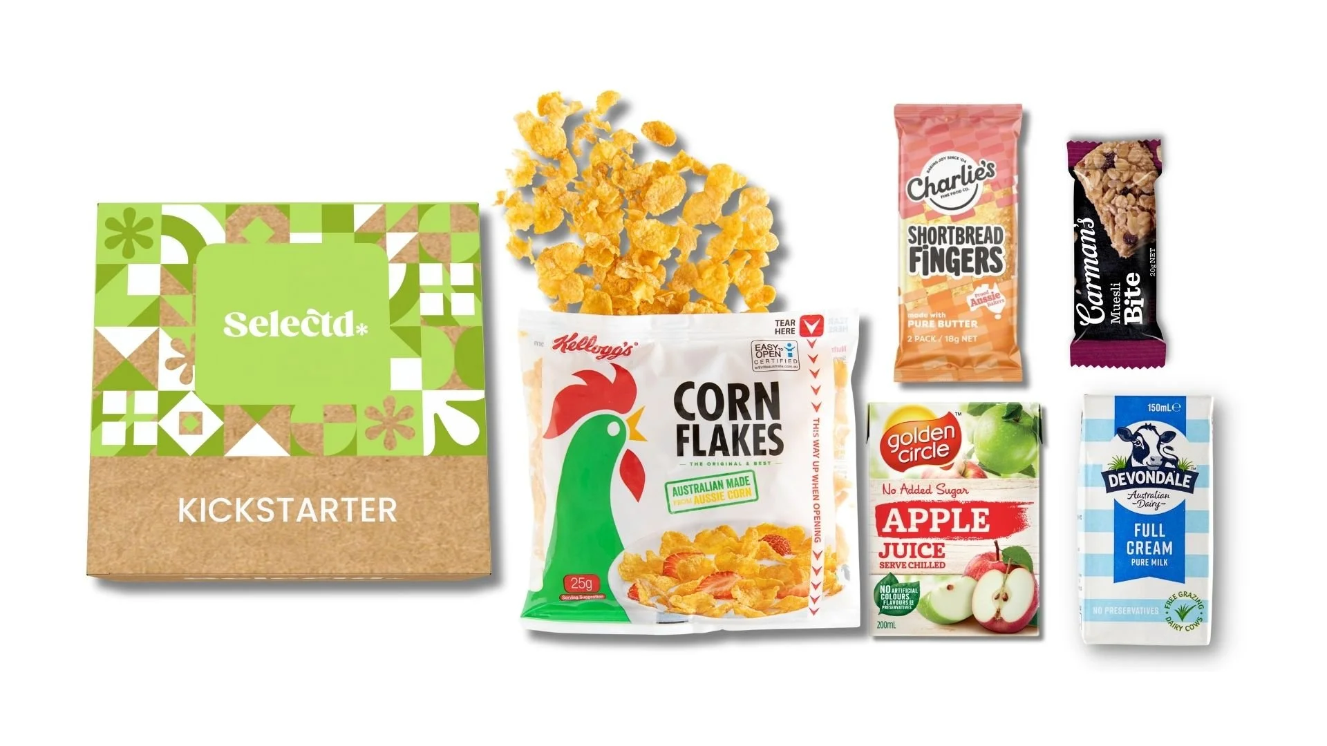 Collection of snacks and beverages, including a card game box labeled 'Selecta Kickstarter,' a bag of corn flakes cereal with a chicken logo, a bag of crispy corn cereal pieces, a small packet of apple juice, a small carton of full cream milk, a packet of shortbread fingers, and a wrapped chocolate biscuit.