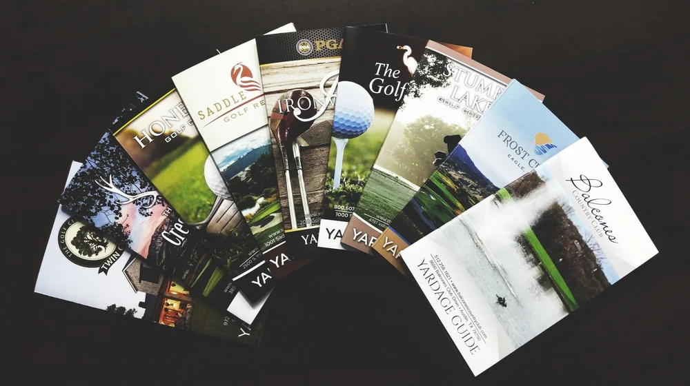 A fanned arrangement of course guides produced for different golf courses