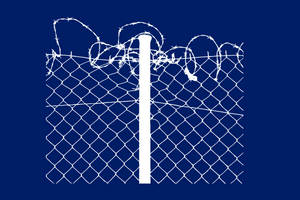 Barbed wire atop a chain-link fence.