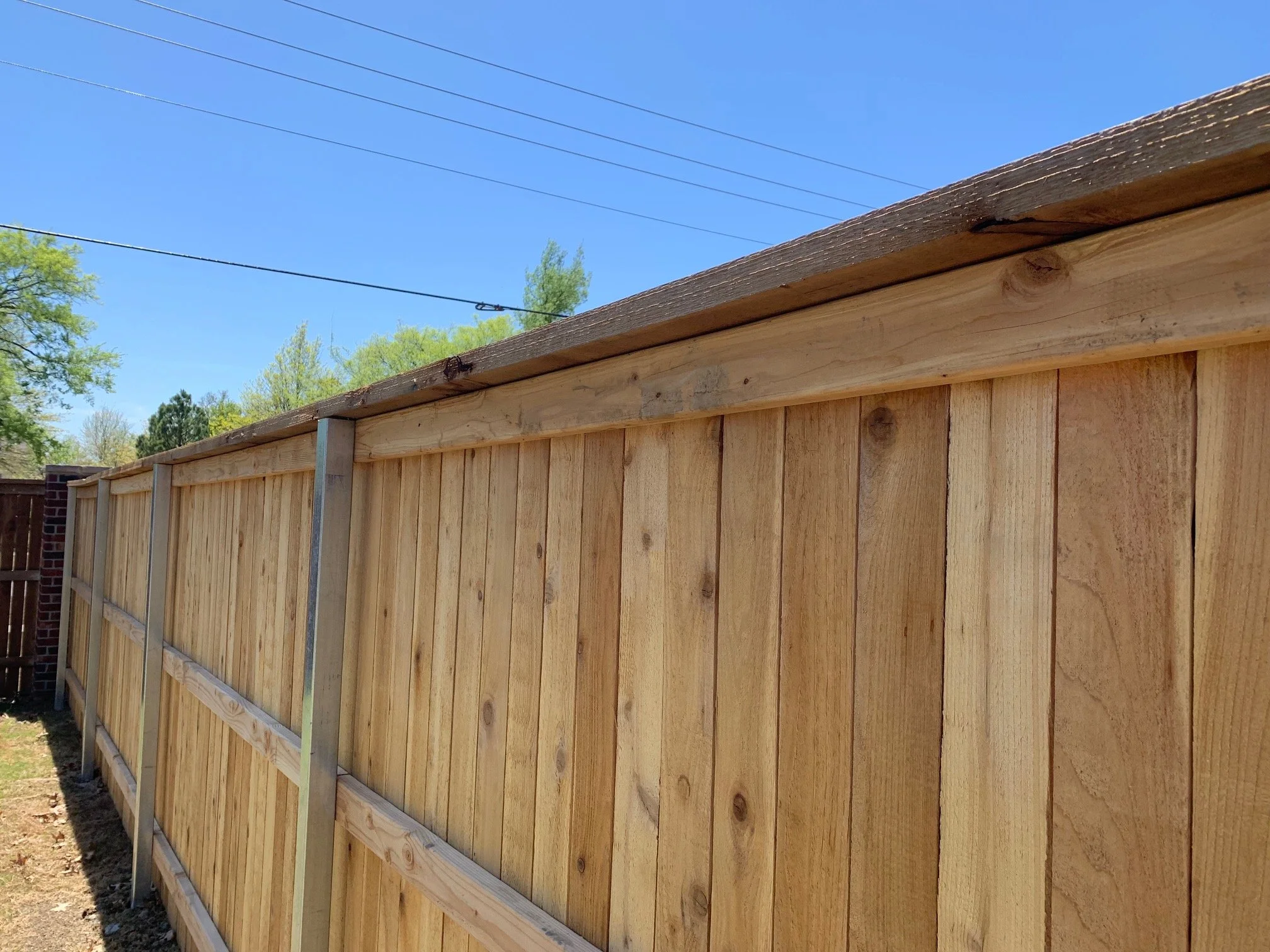 wood fence installed with square tube steel poles