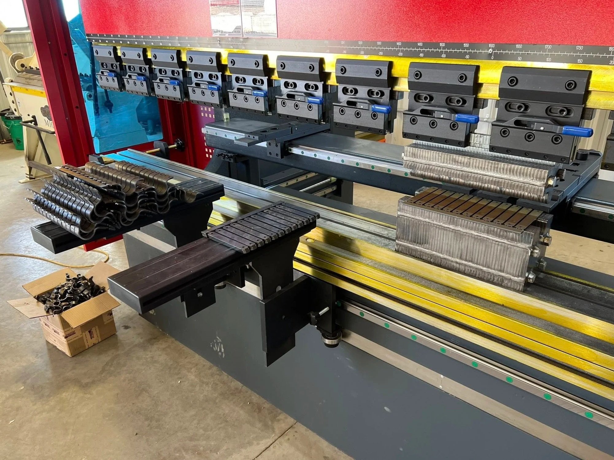 Industrial machine with multiple clamps and metal parts, used for manufacturing or assembly, in a factory setting.