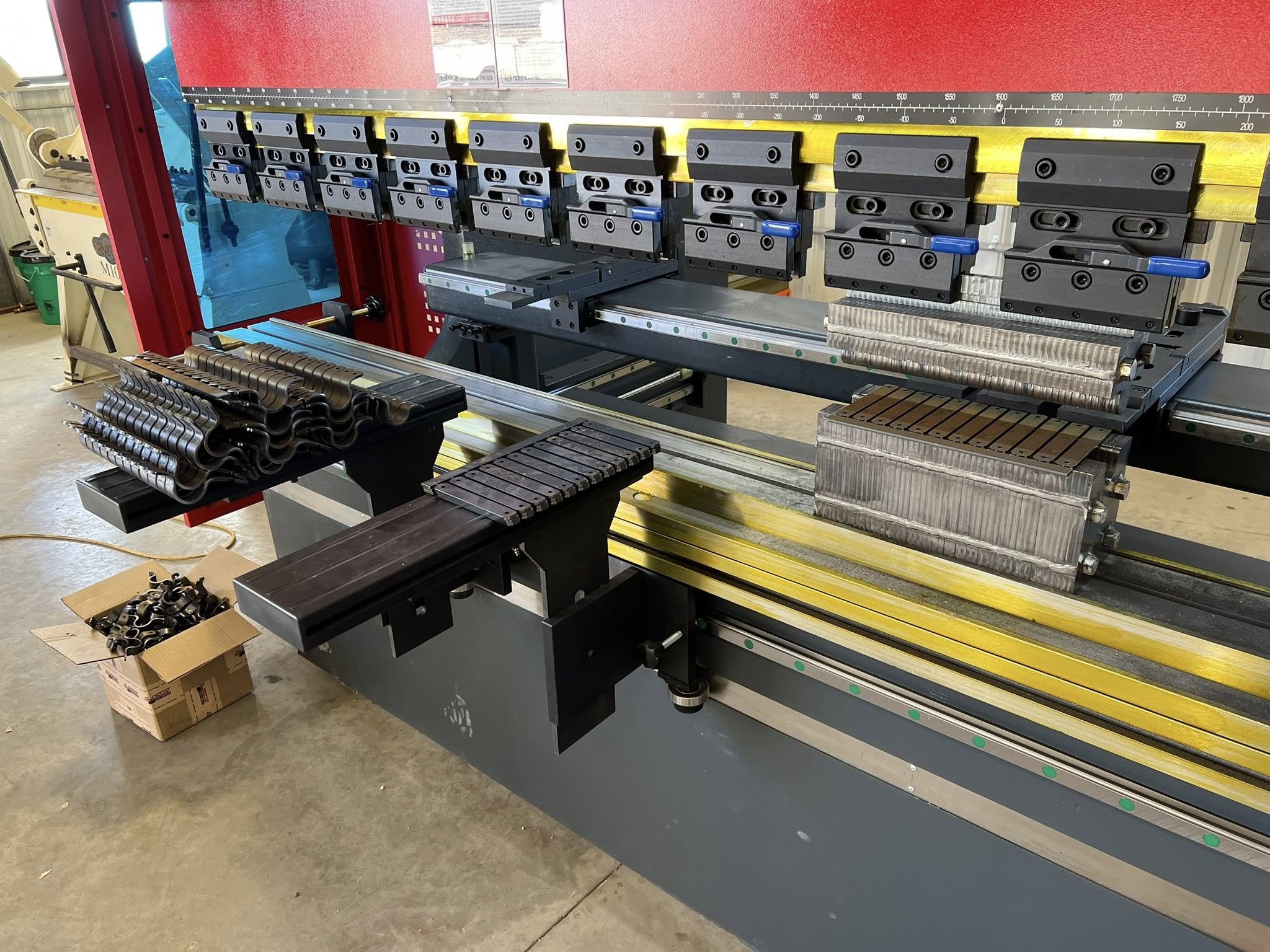 Industrial machine with metal parts and clamps in a workshop.
