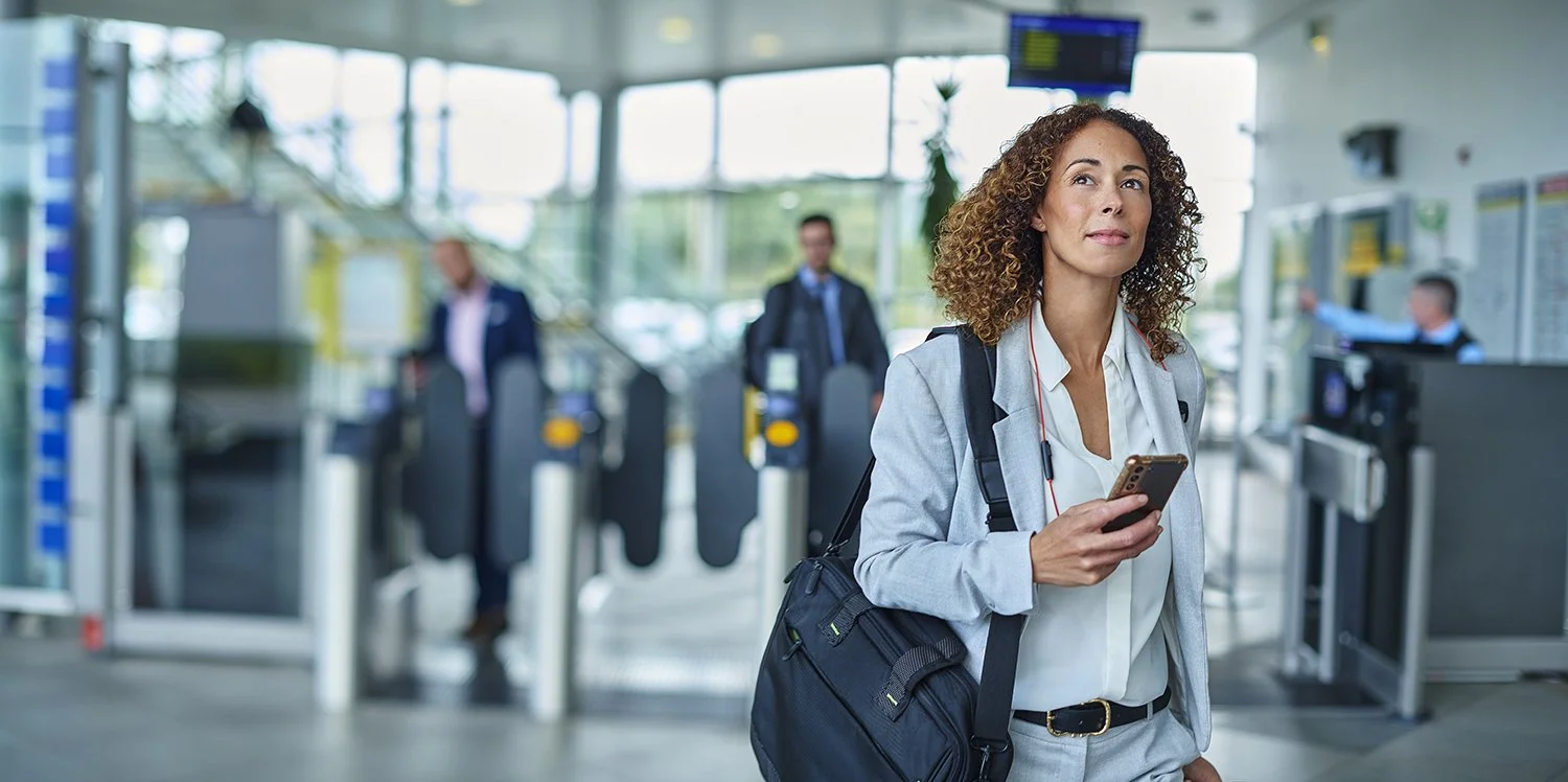 Woman in business attire moving through an airport.