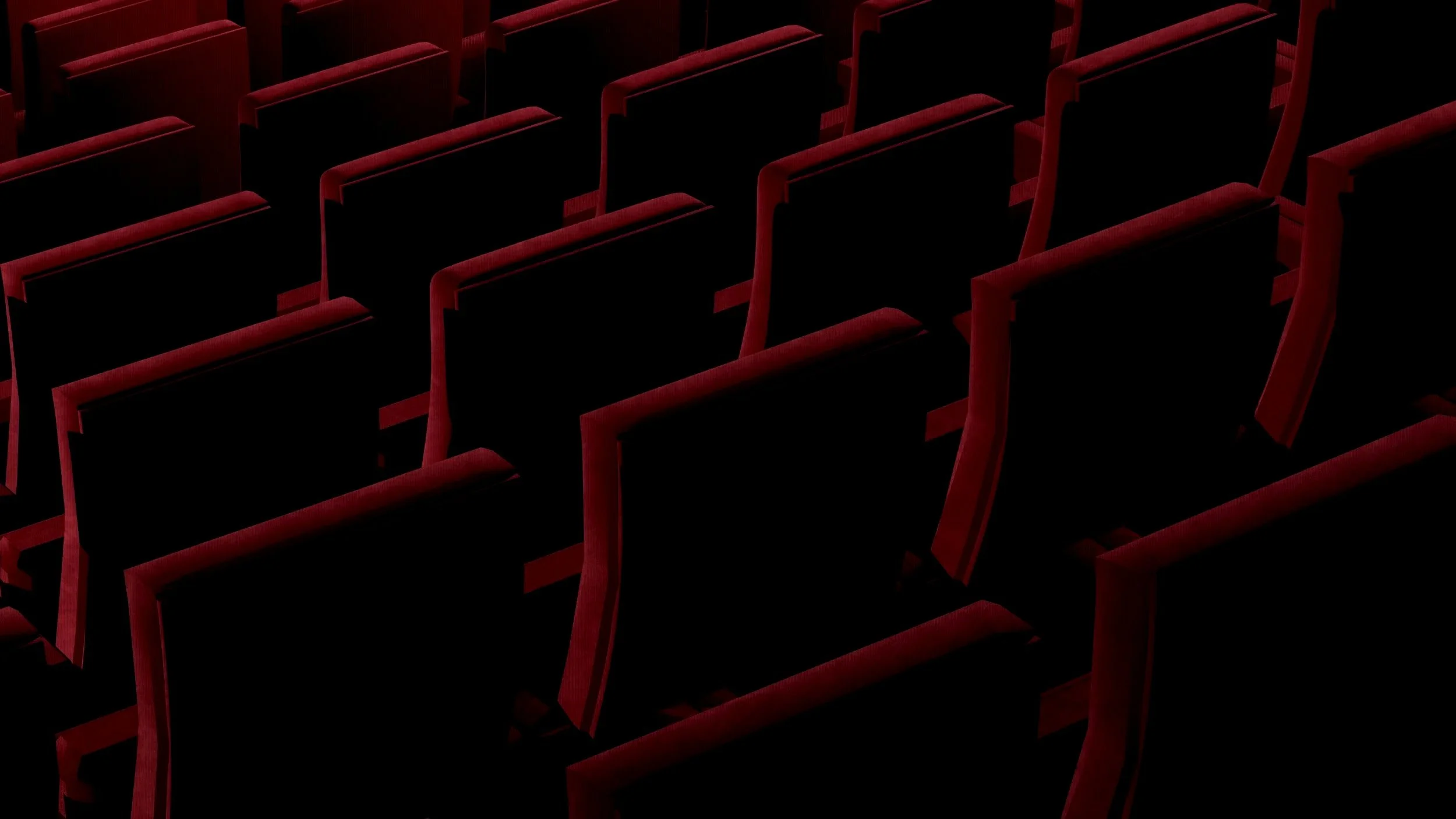 Empty theater seats with red upholstery viewed from above.