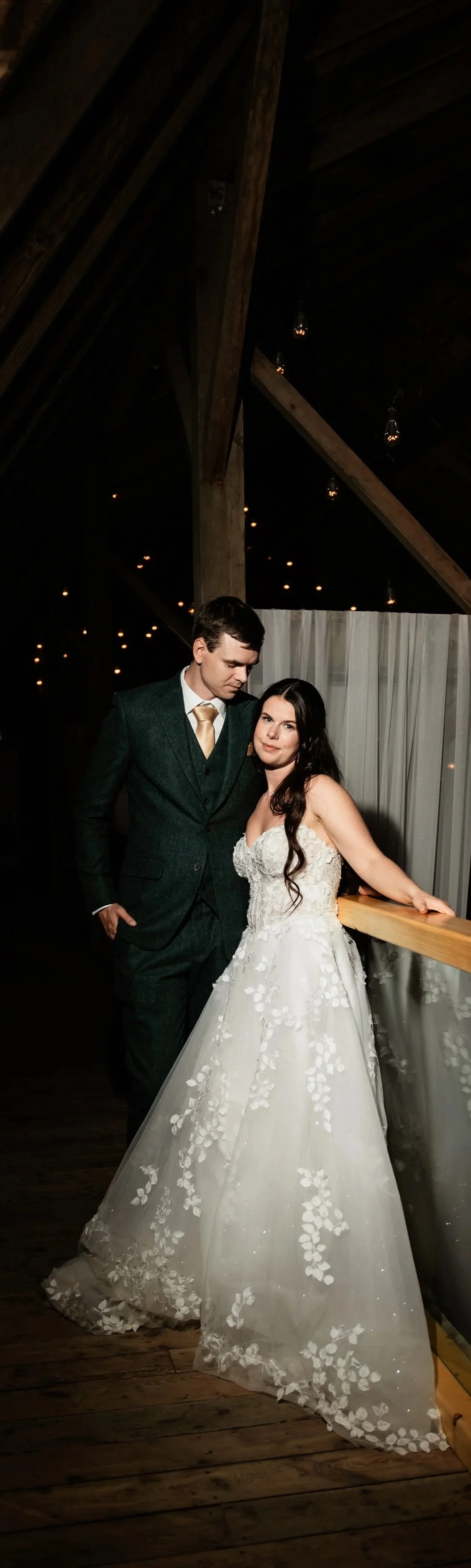 Countryside barn a dimly lit venue with wooden beams and hanging lights. Planned by Den Bosch Events and photographed by The reign Photography in Lethbridge