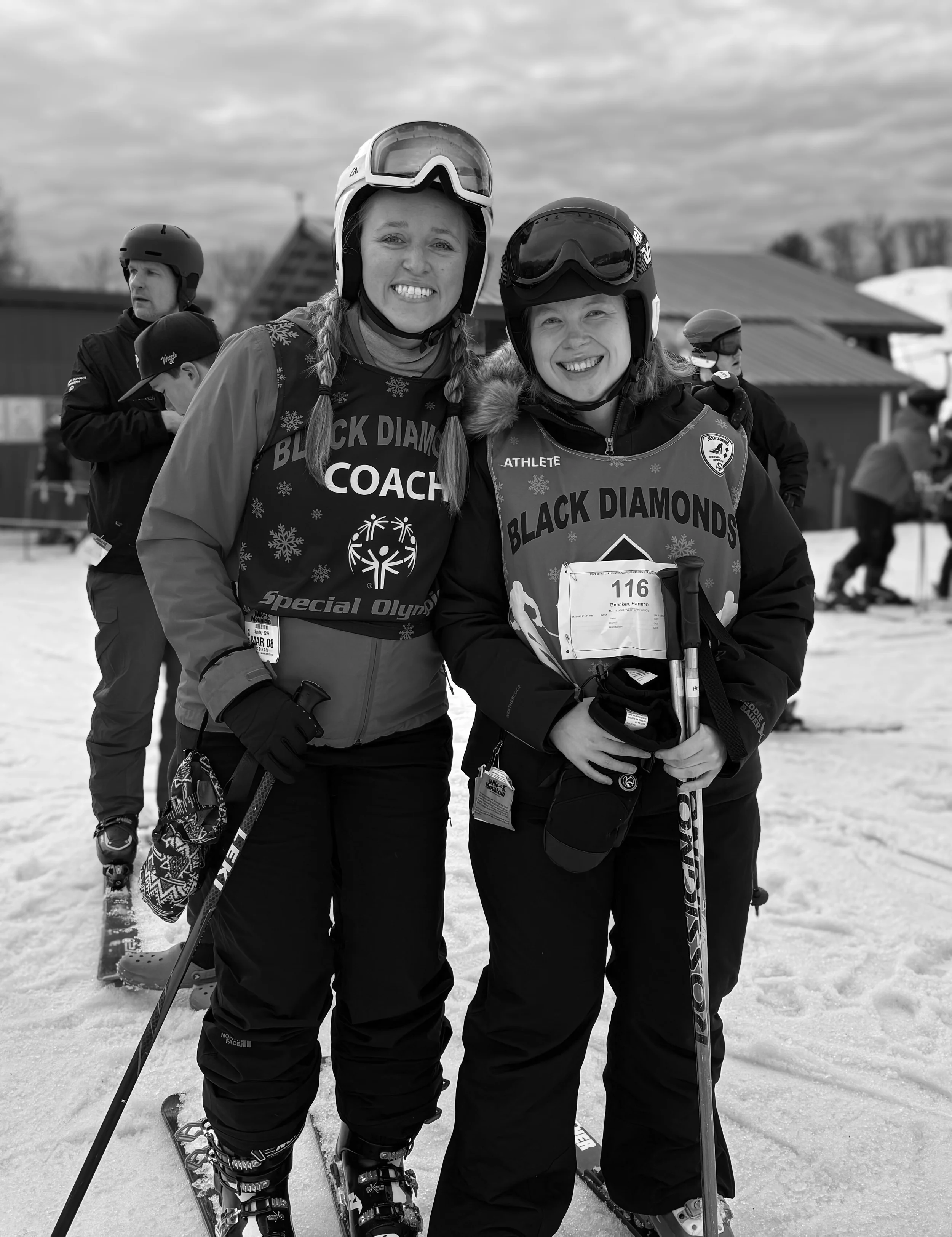 special Olympic coach and mentee wearing their ski gear, smiling