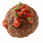 Close-up of a cooked meatball topped with marinara sauce and chopped herbs