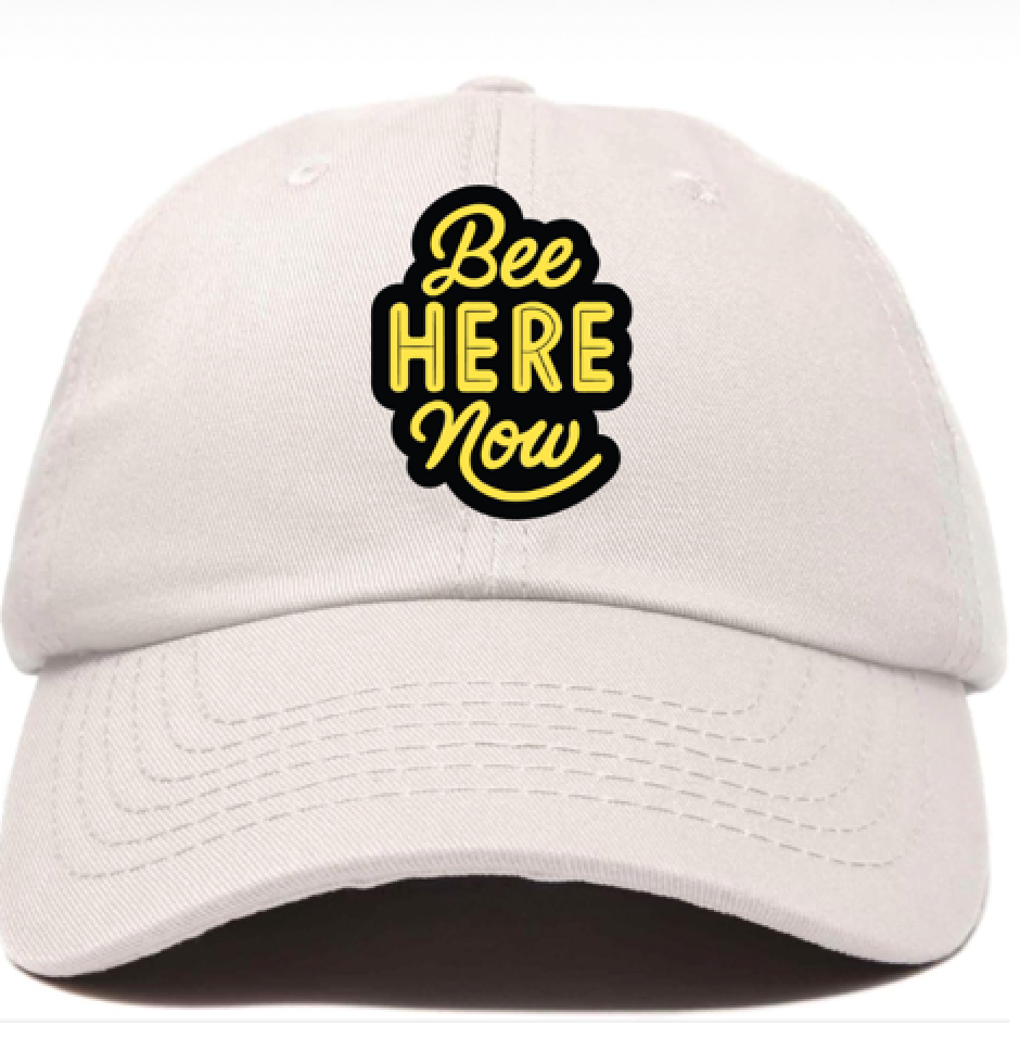 A layout of a ball cap with the message: Bee here now