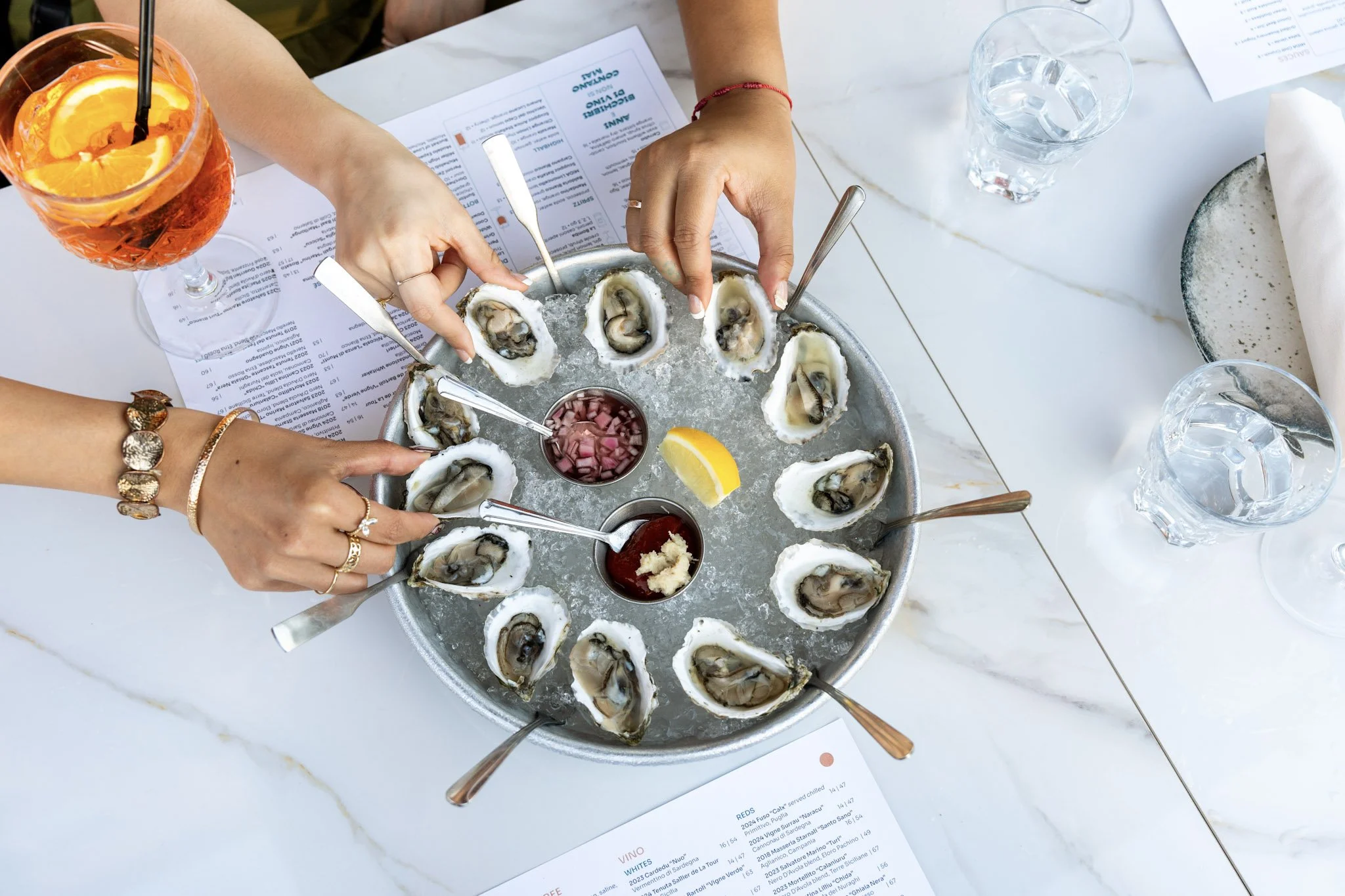 Oysters on ice shared at a table at La Tavernetta by MIDA, East Boston