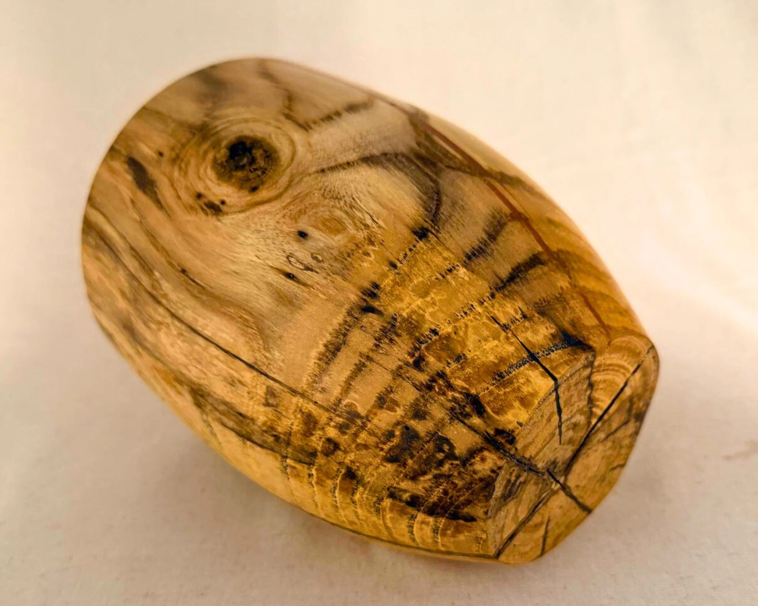 Maple vessel shown on its side to reveal overall form, grain movement, and subtle spalting across the body.