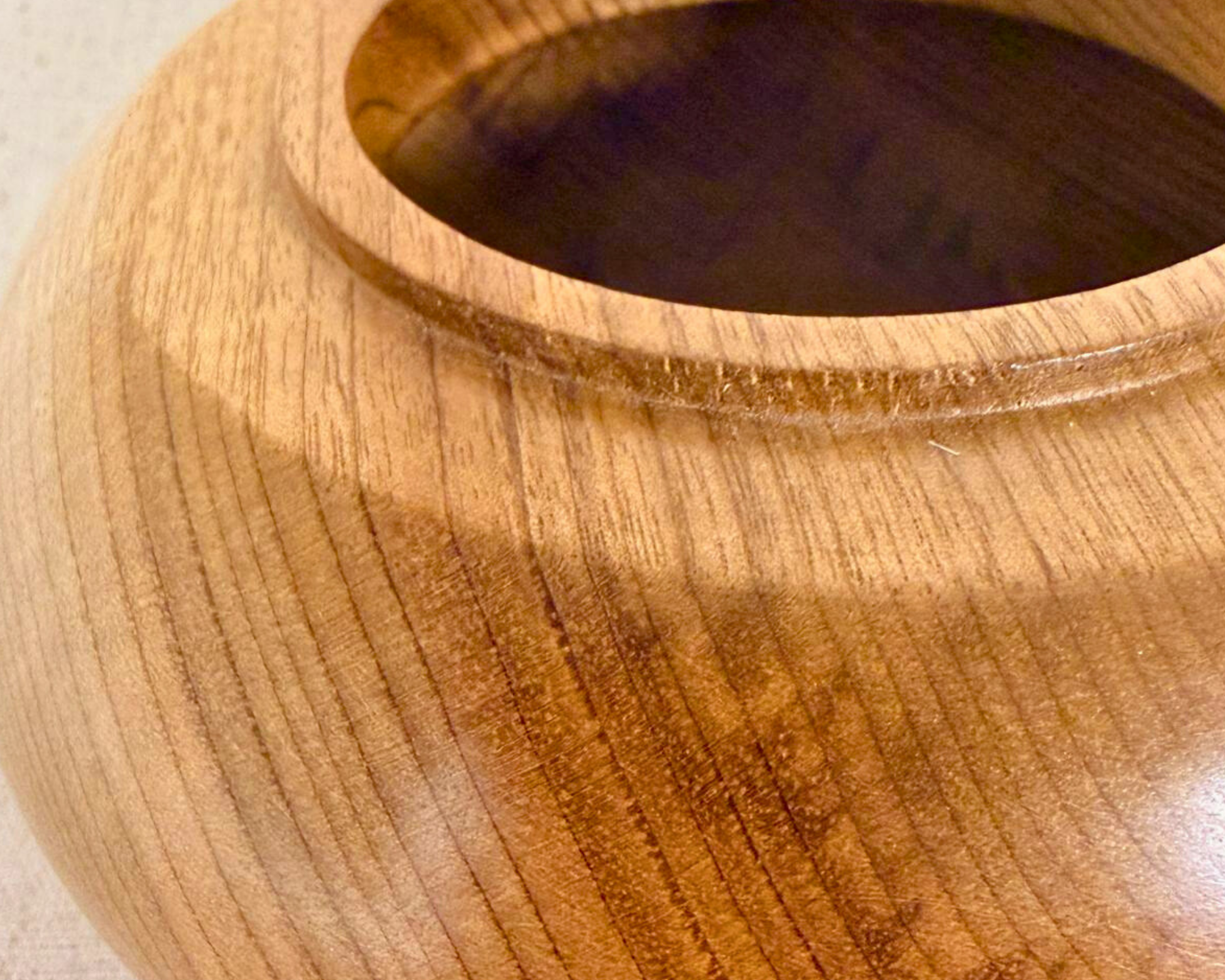 Close-up of the myrtle vessel rim showing fine grain lines, subtle tonal contrast, and the clean transition into the opening.