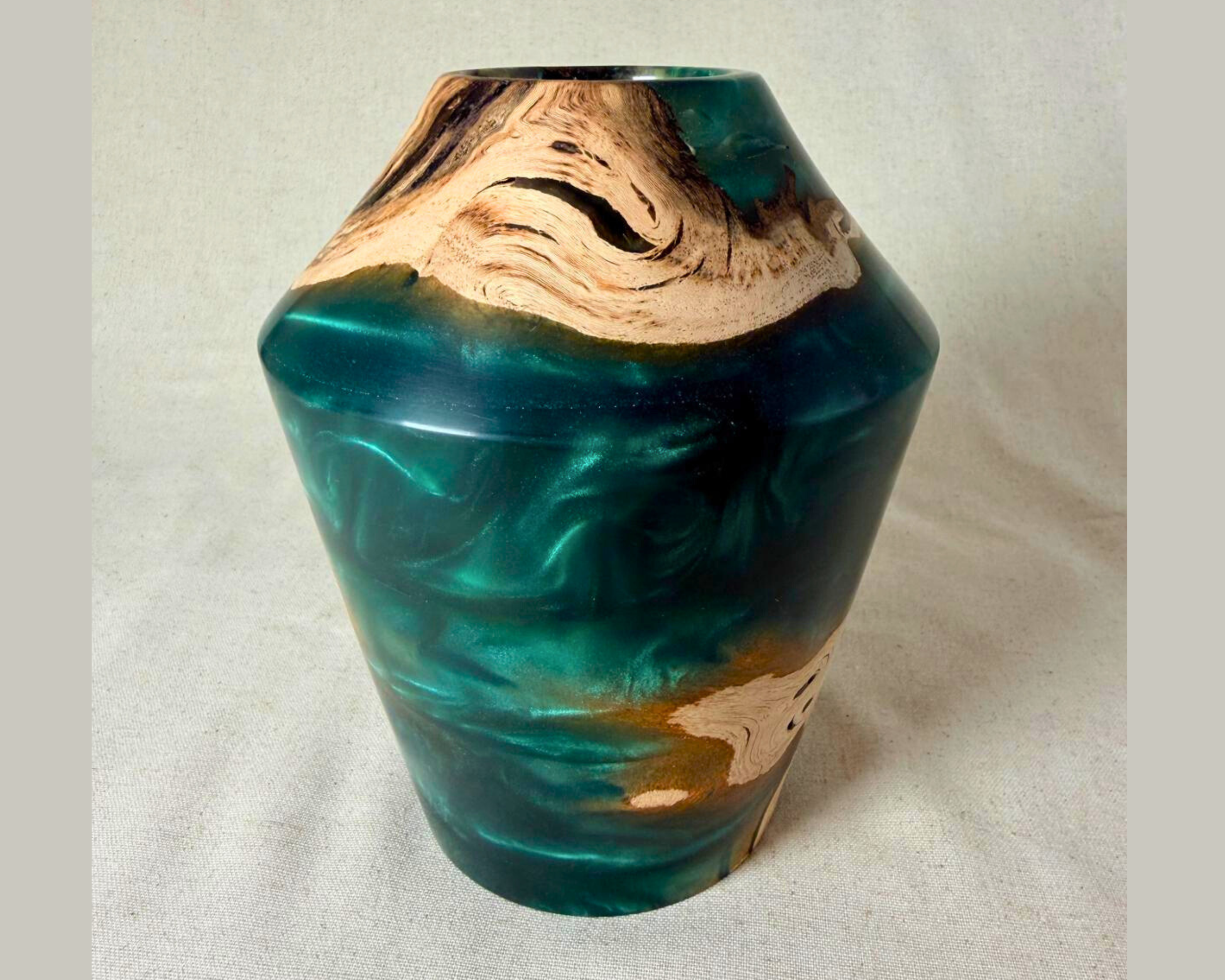 Three-quarter view of driftwood and green epoxy vessel highlighting the vessel’s angular shoulder, organic driftwood edges, and layered green resin movement.