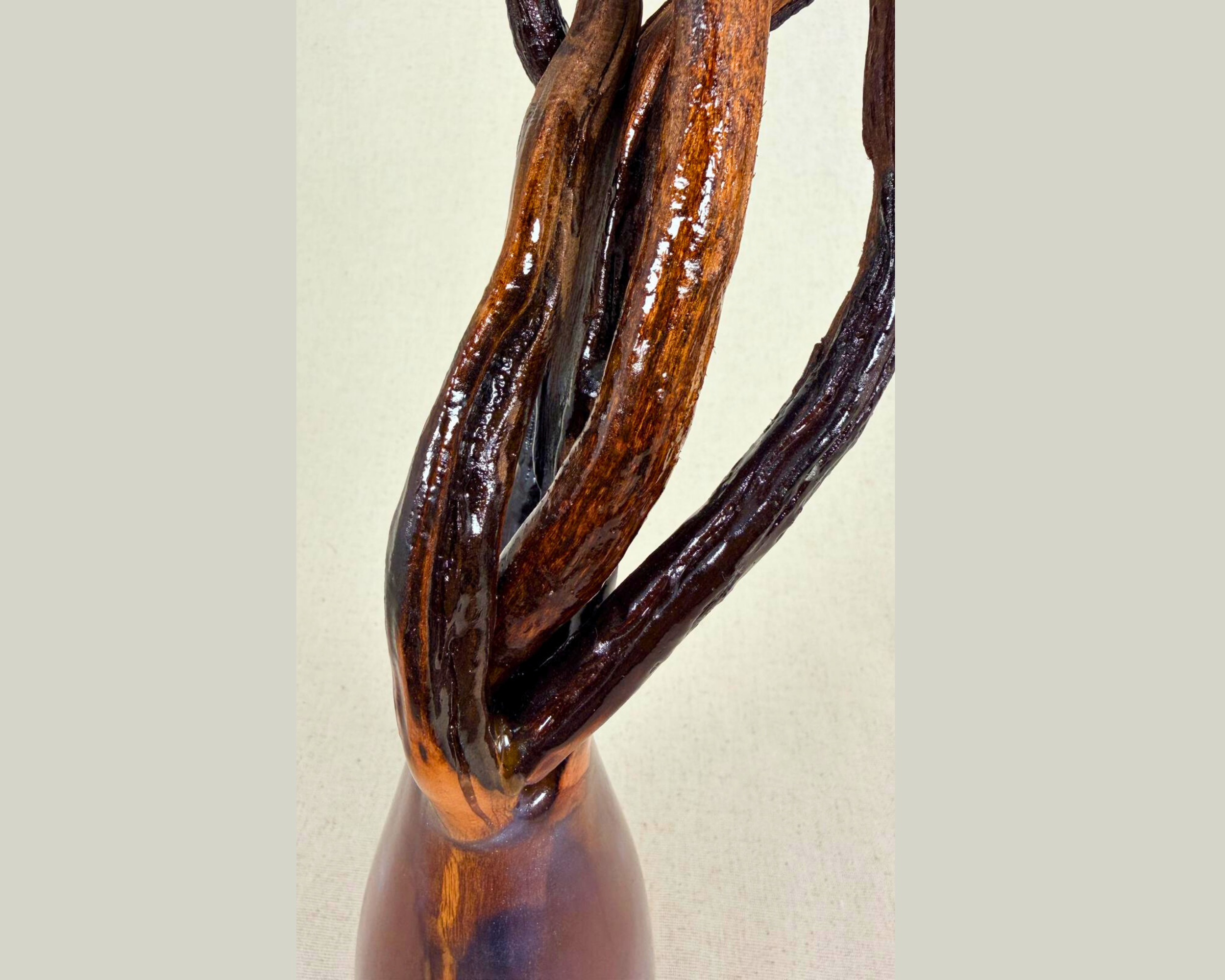 Close-up of the upper sculpture showing intertwined natural driftwood branches emerging from the epoxy form.