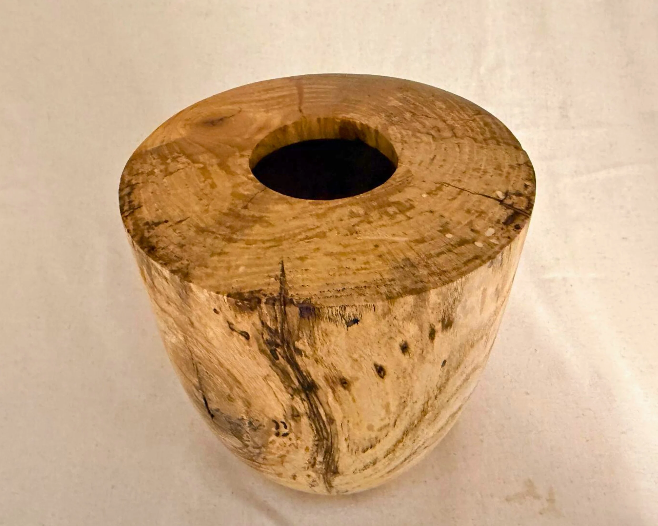 Angled top view of the maple vessel highlighting the flat top surface, centered opening, and circular grain pattern.