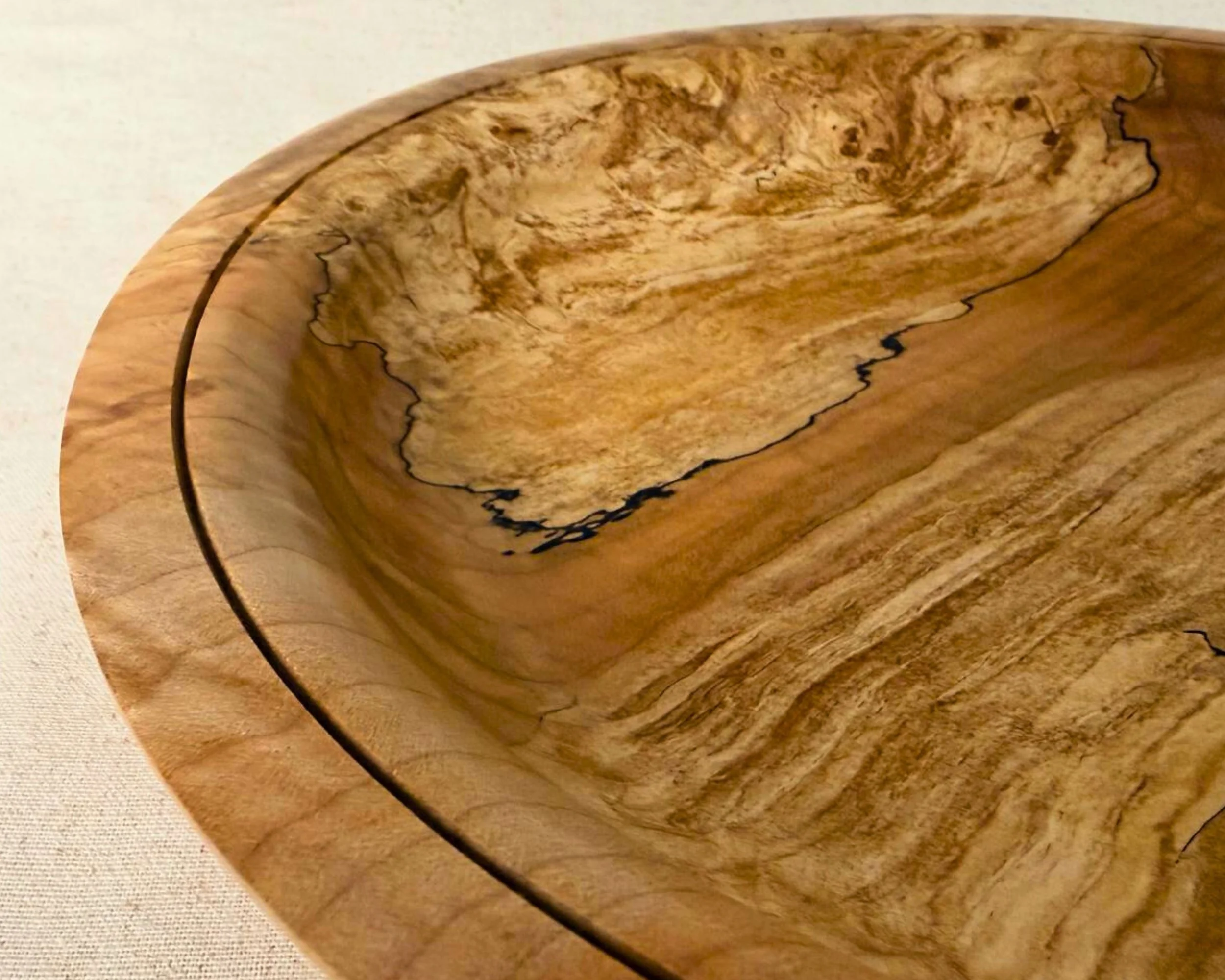 Close-up of the platter interior showing spalted figure and dark spalt lines, smooth finish, circular groove detail near rim.