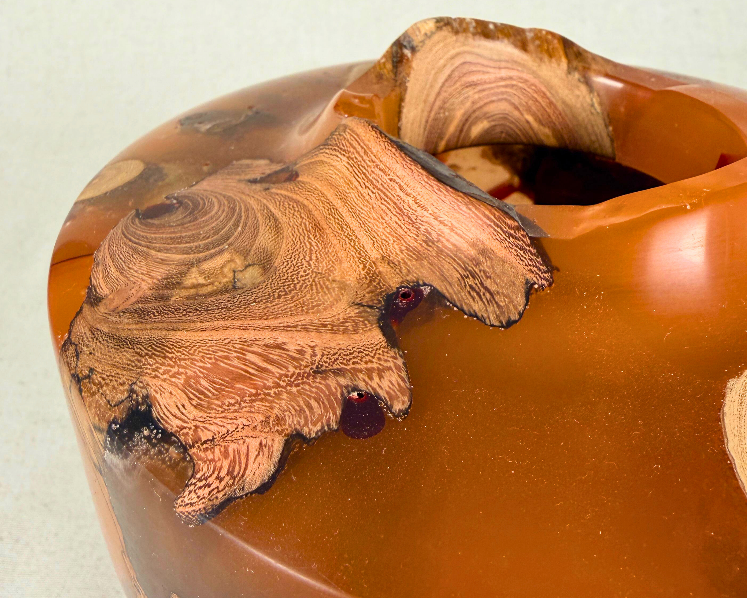 Detailed view of the vessel’s rim and driftwood inclusions set in ochre and amber epoxy, highlighting natural grain, organic edge transitions, and sculptural form.