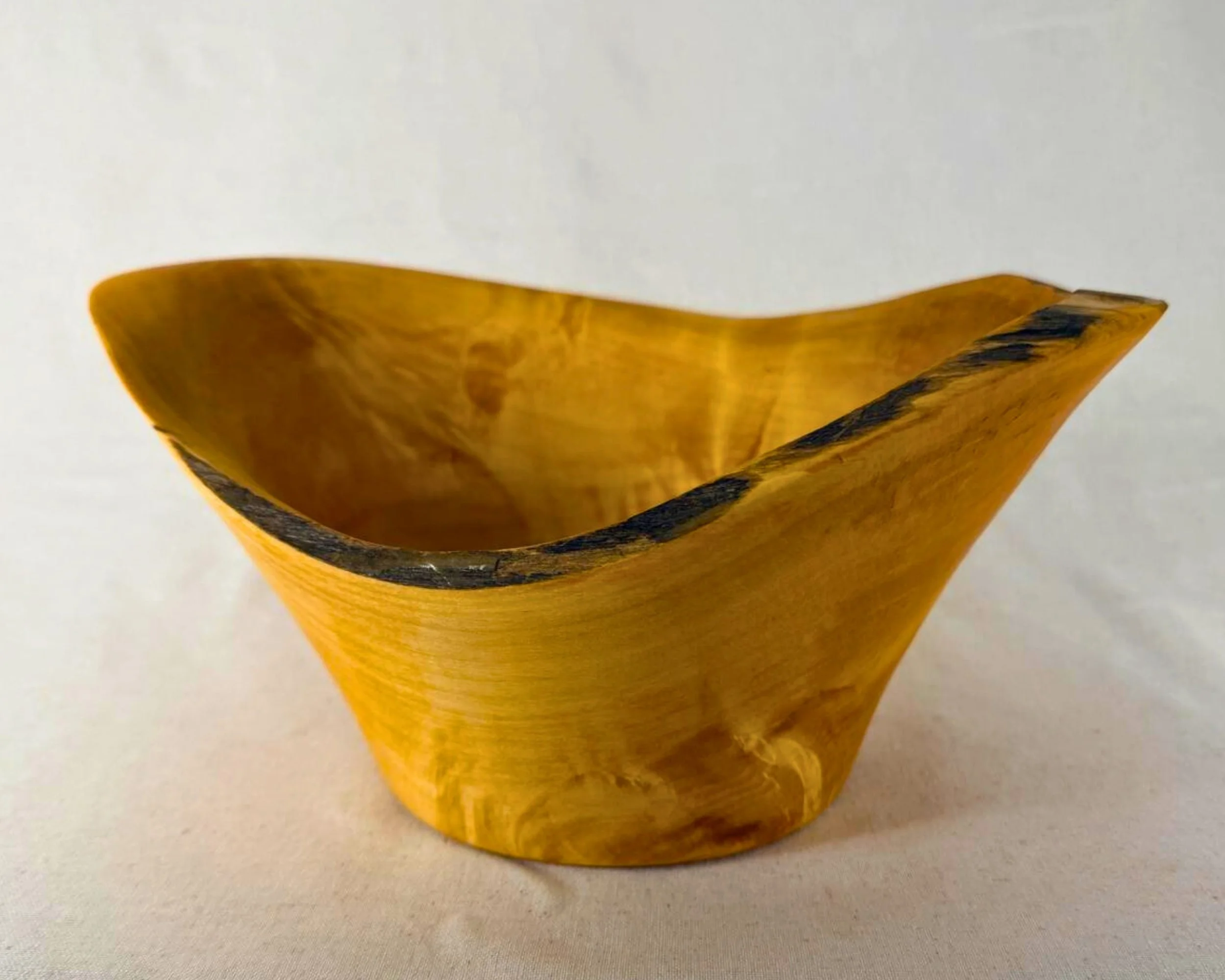 Front hero view of reclaimed pine natural edge vessel with lifted rim and dark bark line.