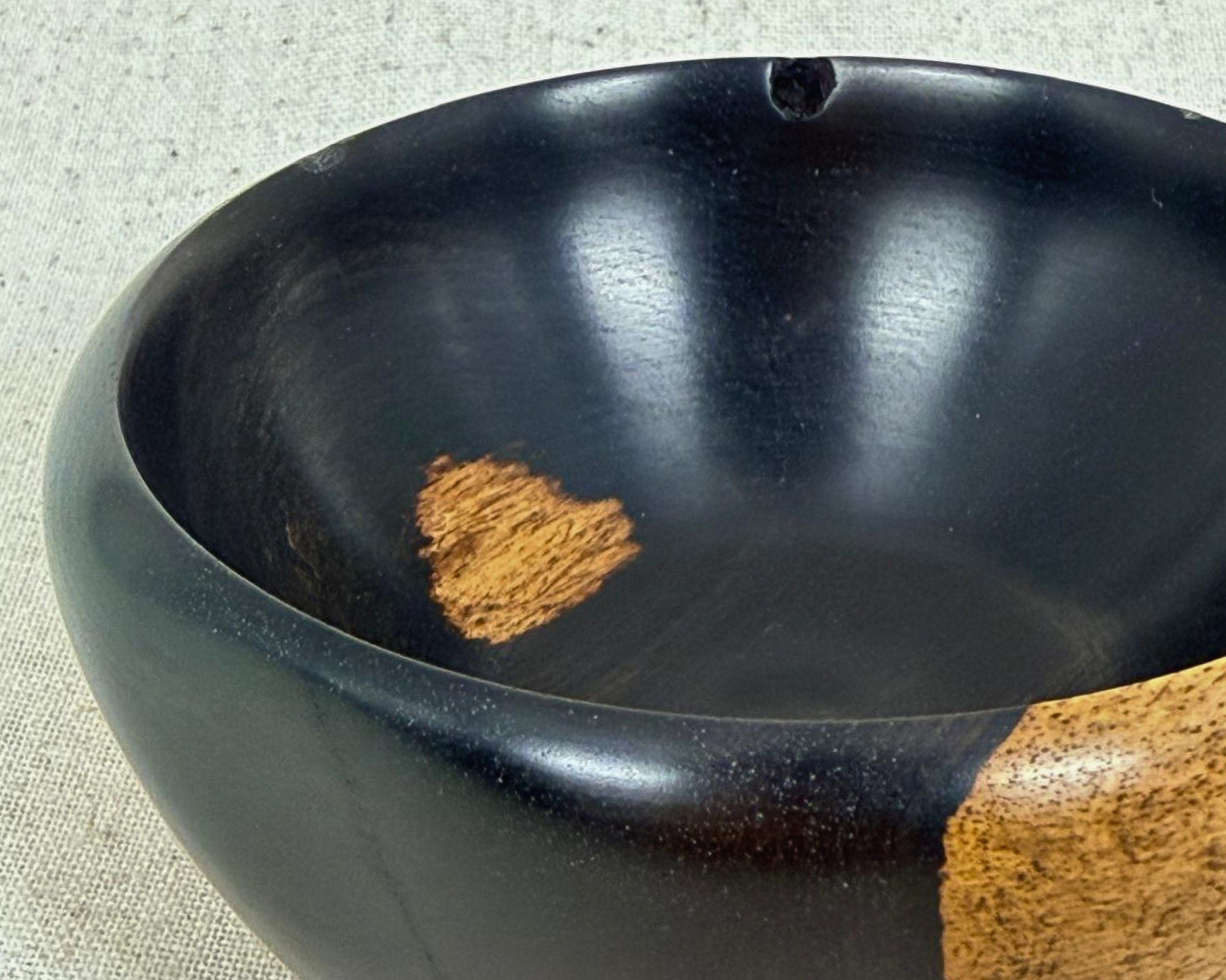 Close-up of the African Blackwood bowl interior showing the dark finish, rim line, and contrasting natural wood inclusion.