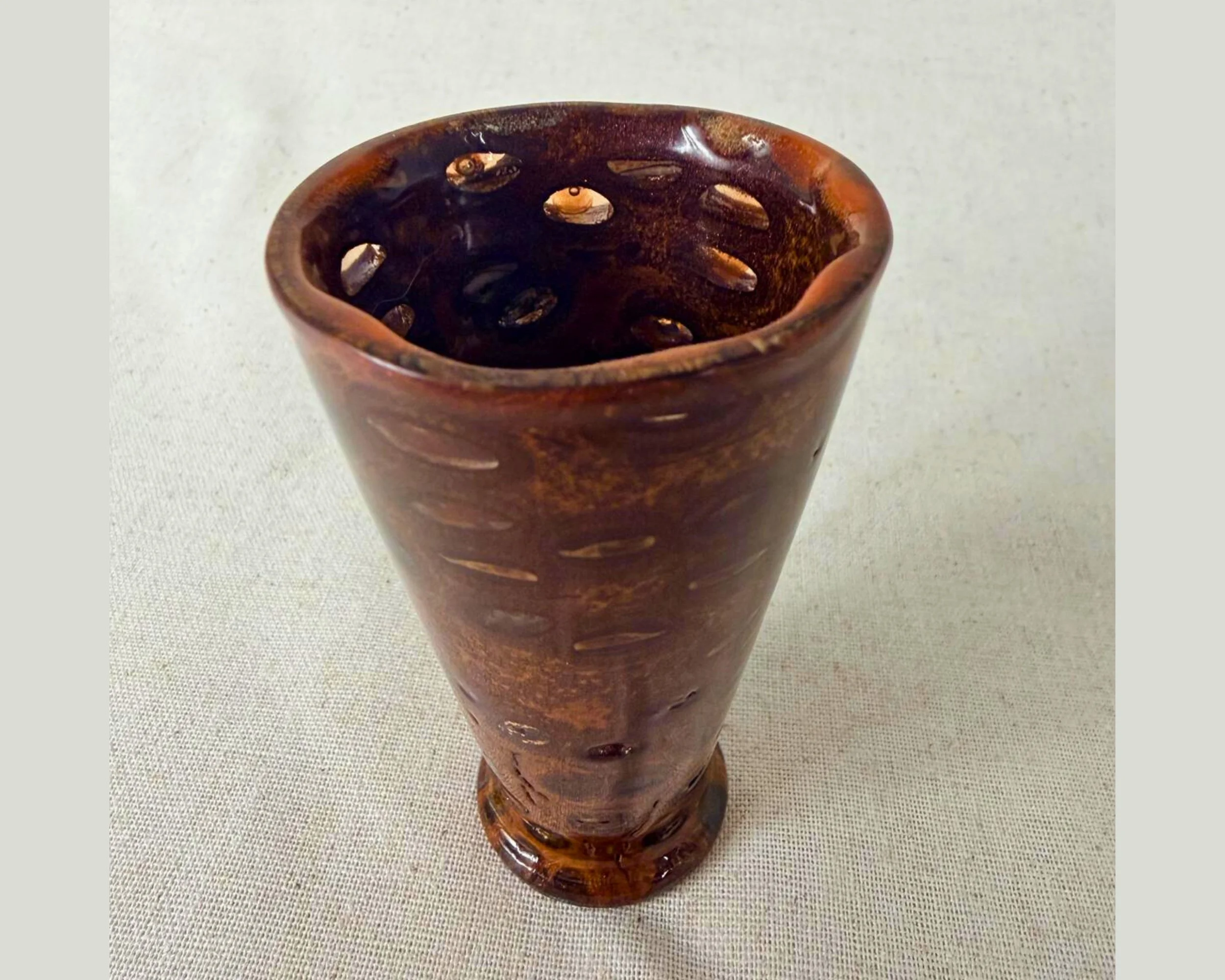 Close-up inside view of a banksia nut vessel highlighting red epoxy fills, including areas that appear translucent.