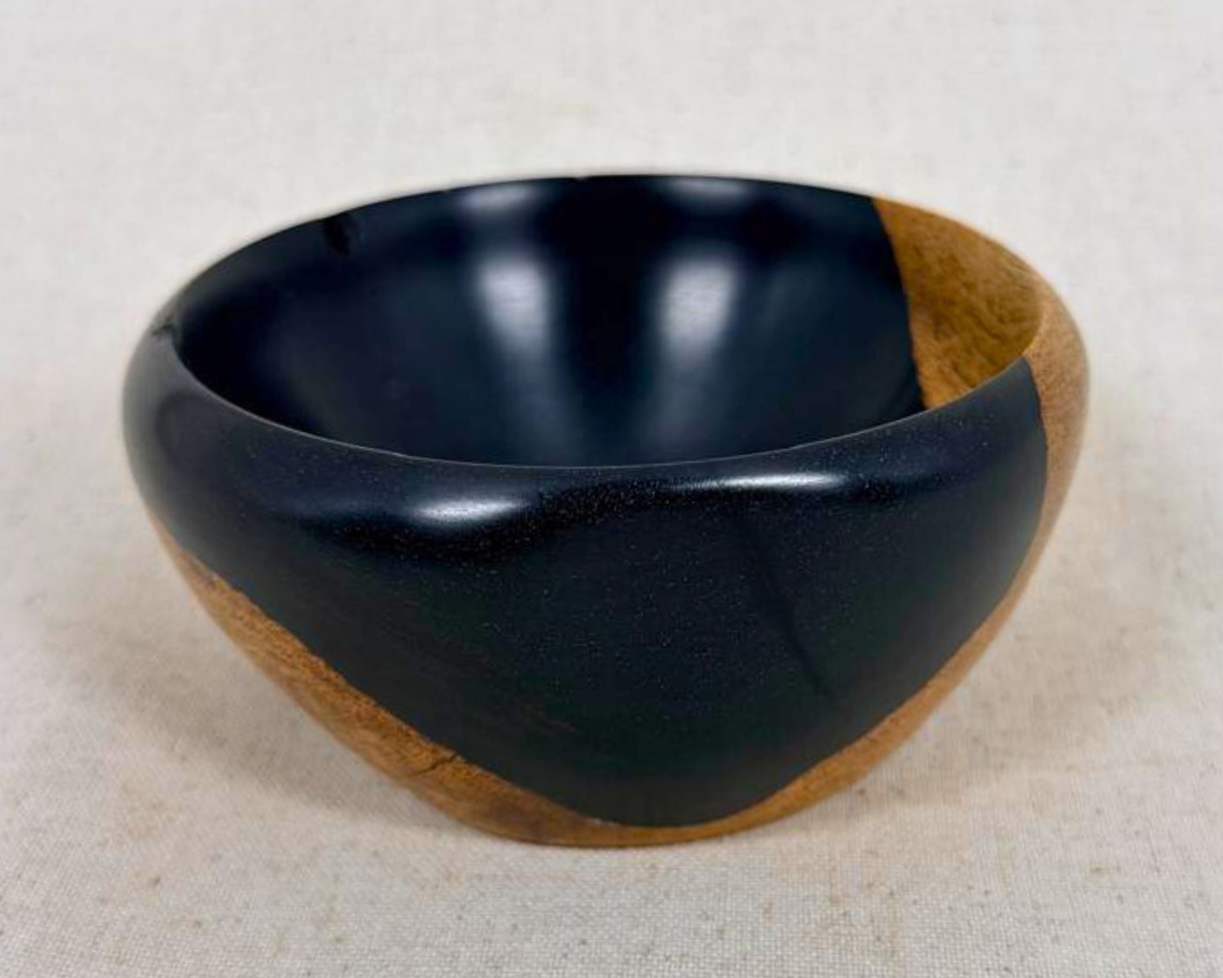 Tilted profile view of the African Blackwood bowl emphasizing the asymmetrical base and sculptural underside.