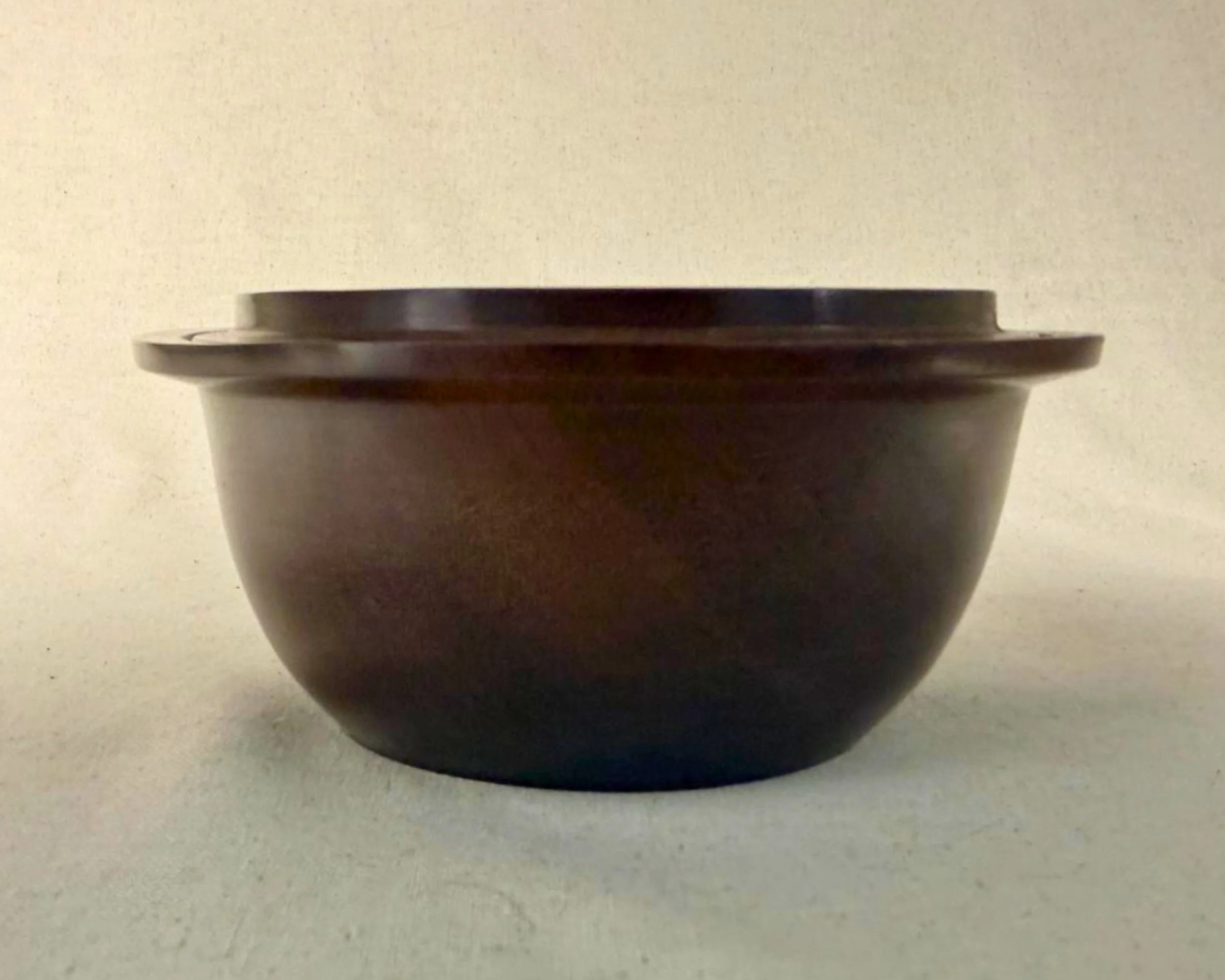 Side profile of rosewood bowl, 2.75 inches tall with wide stepped rim.