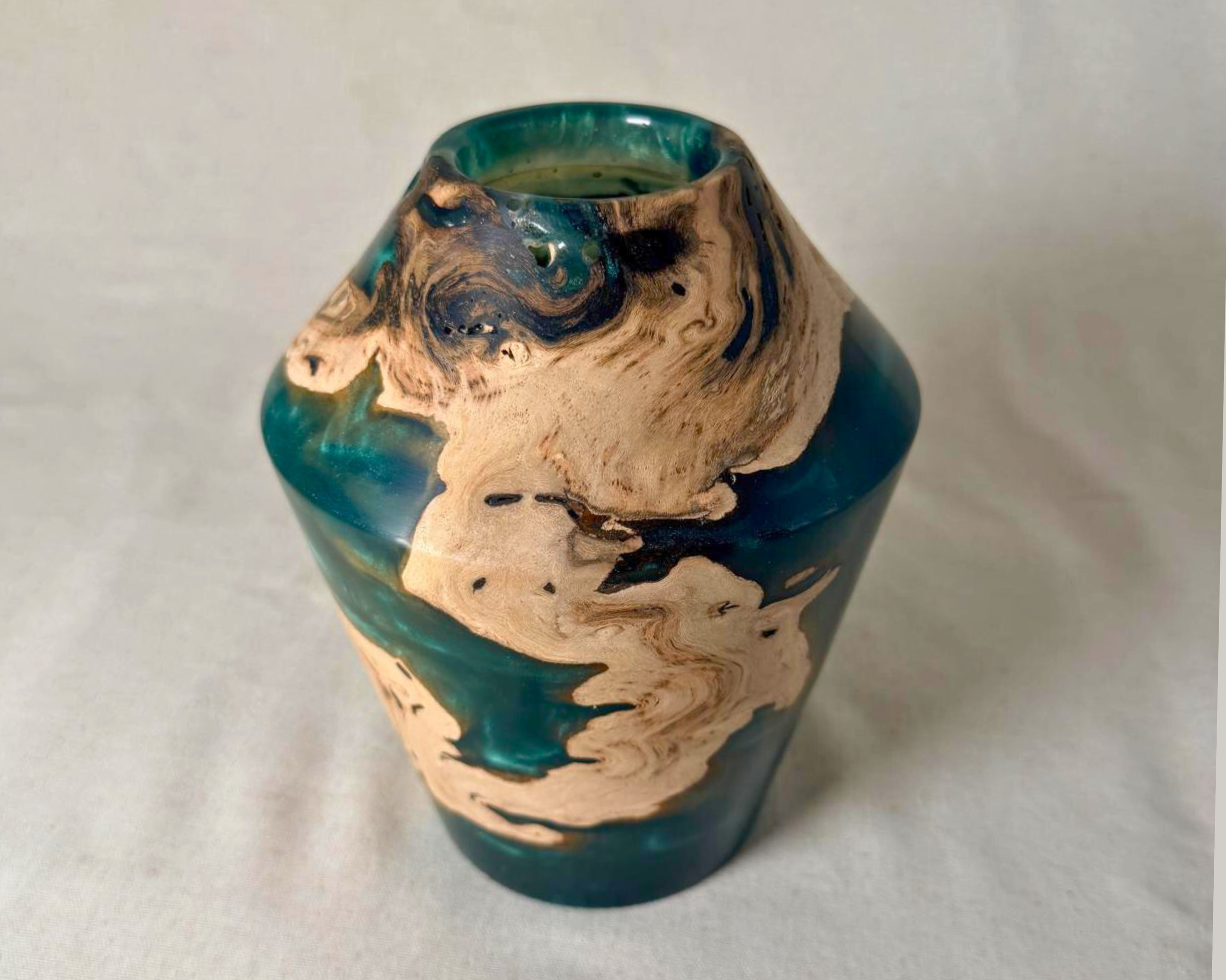 Front view of a driftwood and green epoxy vessel with a sculptural tapered form, narrow opening, and dramatic contrast between pale wood and luminous green resin.