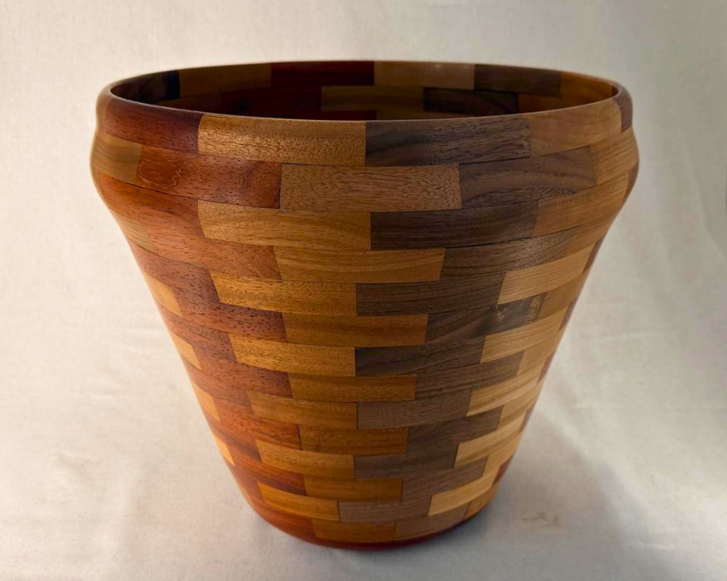 Full view of large segmented wood vessel with brickwork pattern and warm mixed hardwood tones.