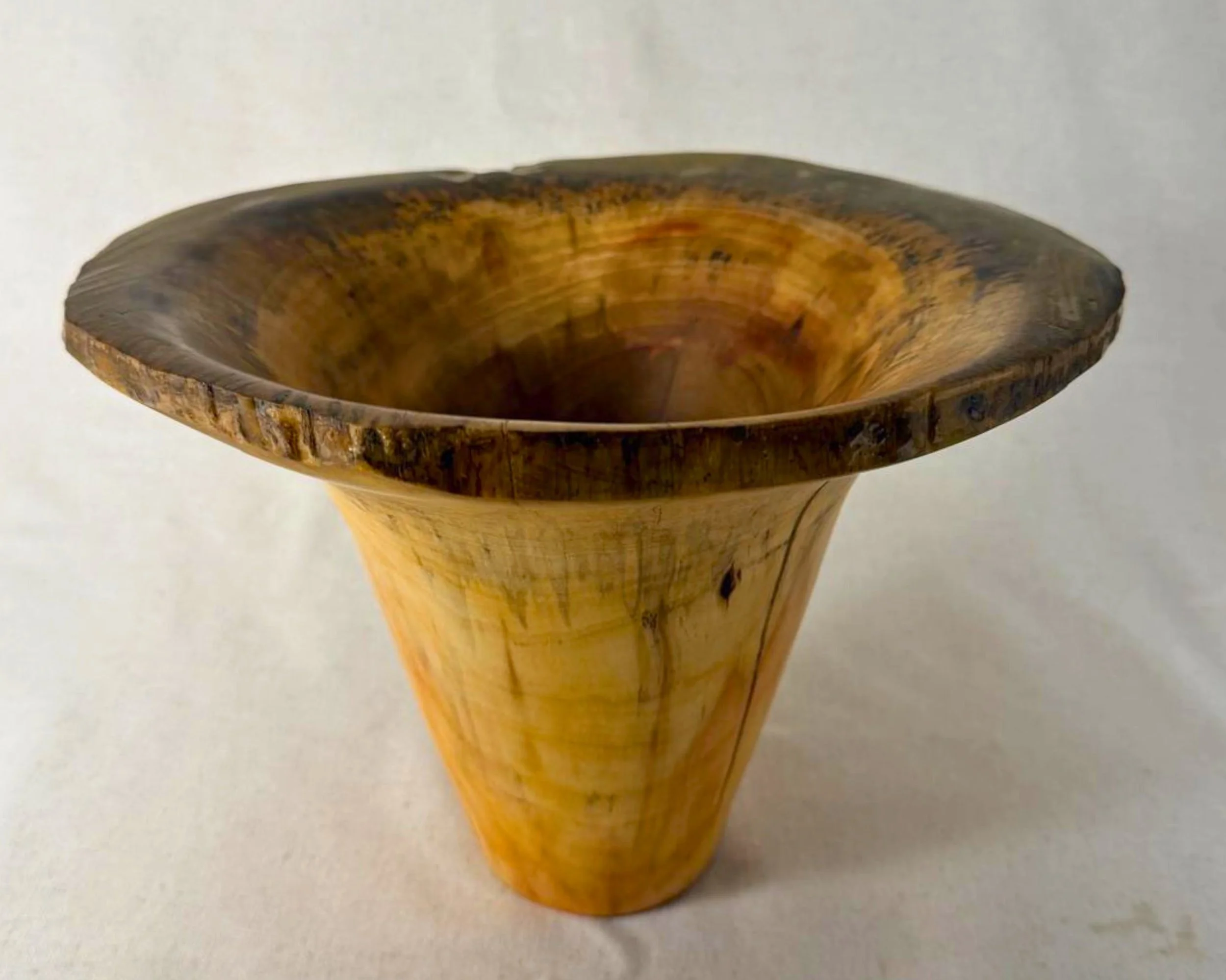 Hand-turned maple vessel with wide natural-edge rim and multi-toned epoxy, front view on neutral backdrop.