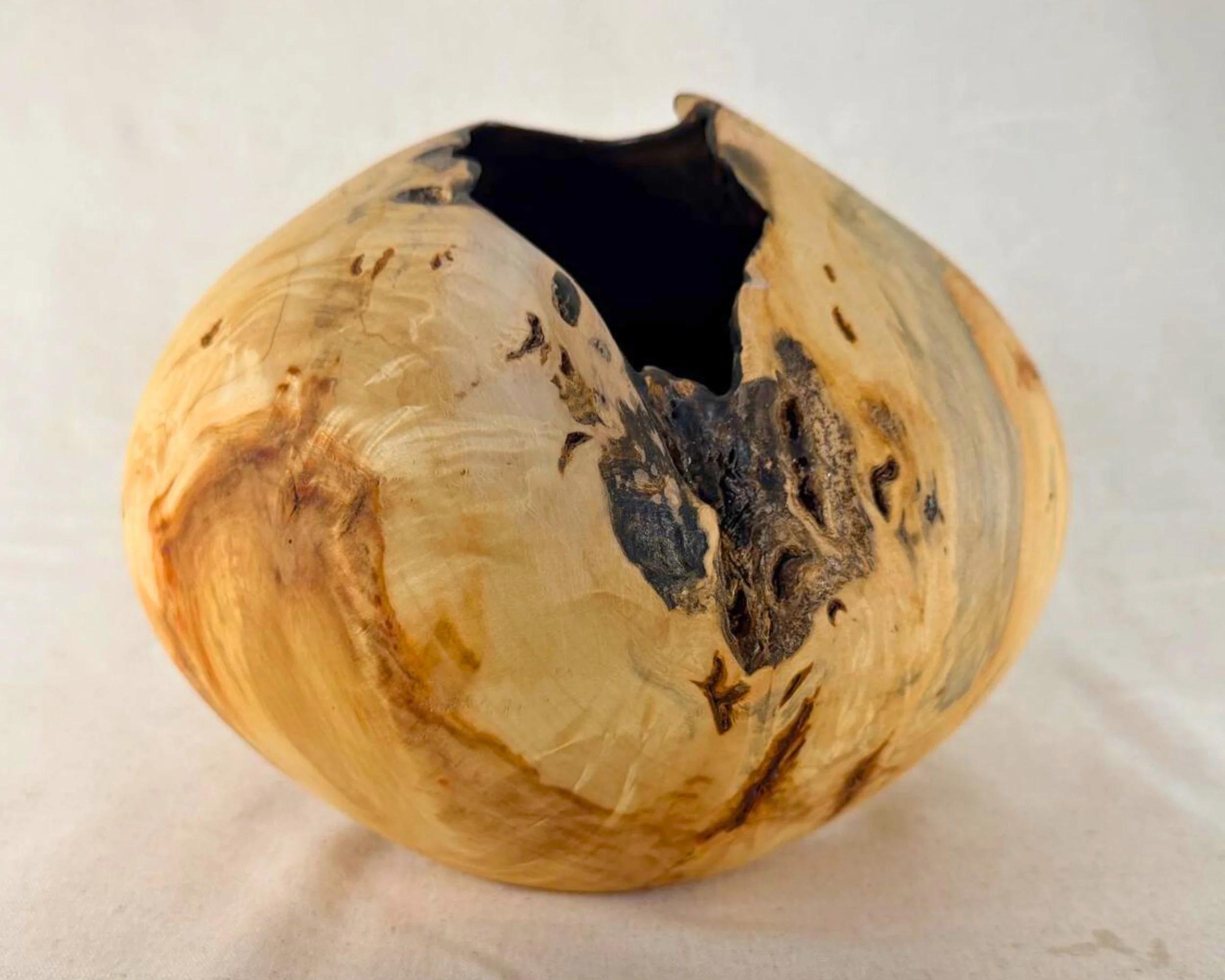 Reclaimed pine sculpture shown at a slight angle, highlighting the jagged rim and black epoxy-coated interior.