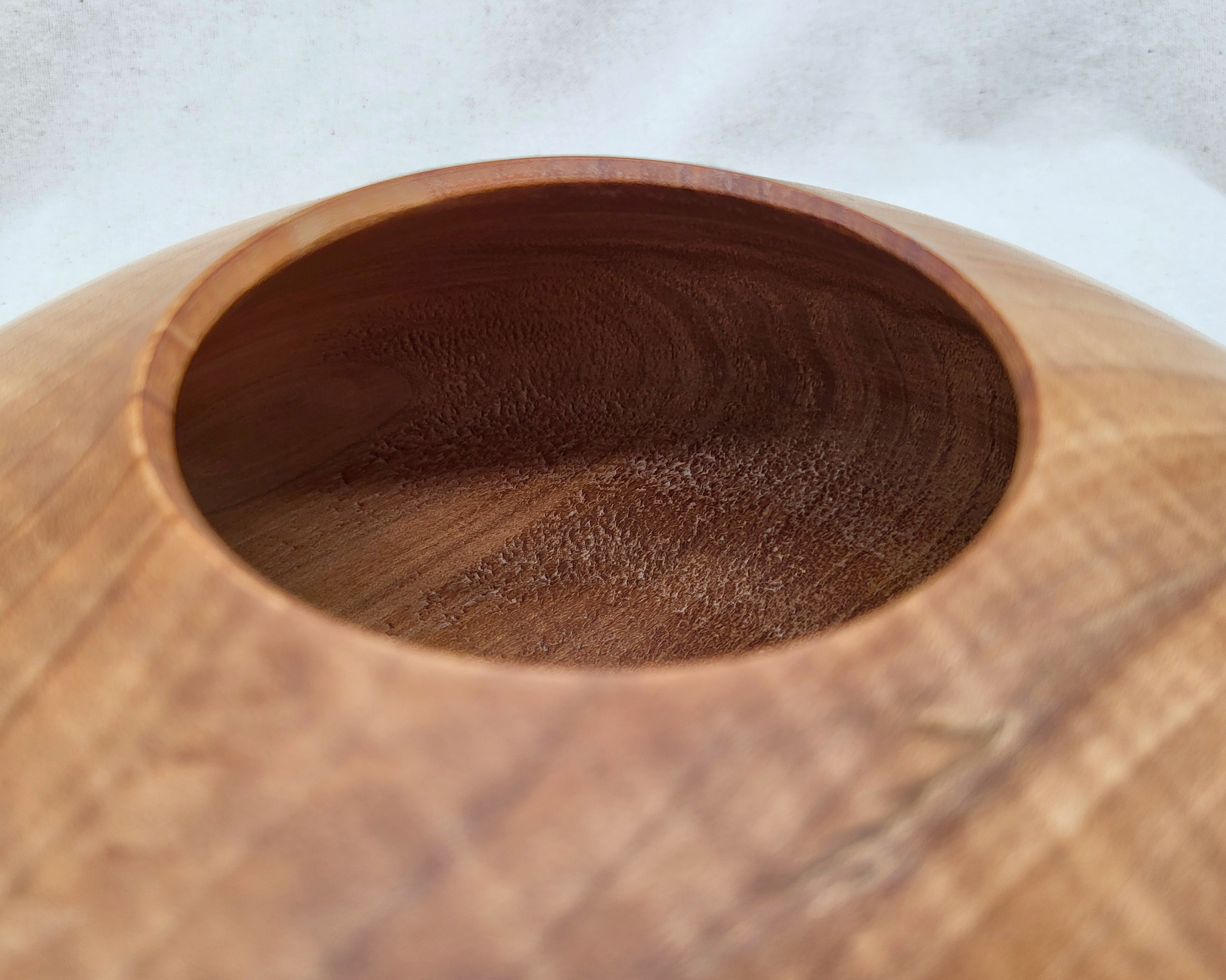 Detail of the 3.25-inch top opening on a hand-turned curly maple closed-form vessel by Treverk Woodturning, showing the cleanly cut rim and warm endgrain interior of this hollow wood vessel.