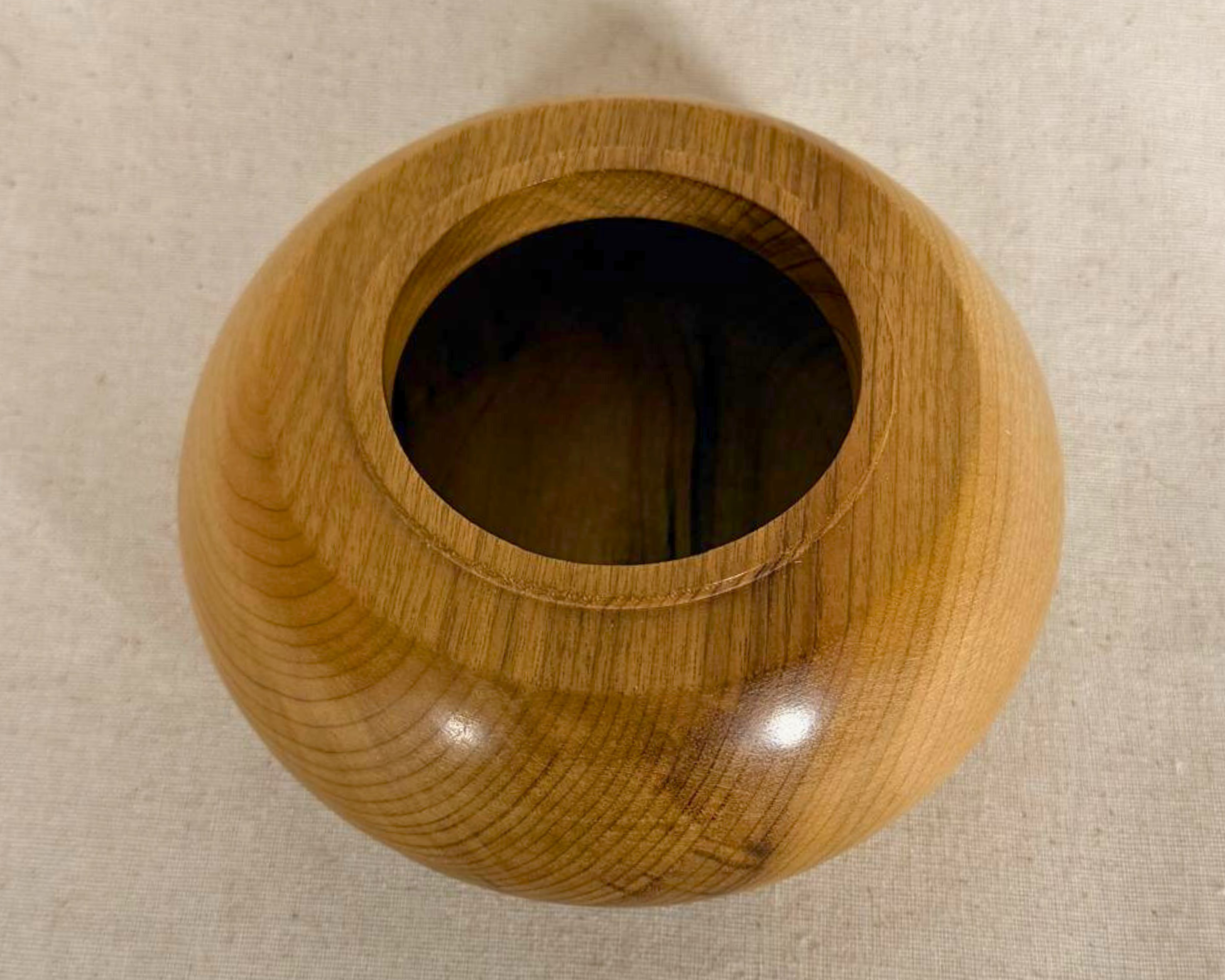 Top view of a myrtle vessel with a central opening, warm natural wood tones, and delicate grain variation around the shoulder.