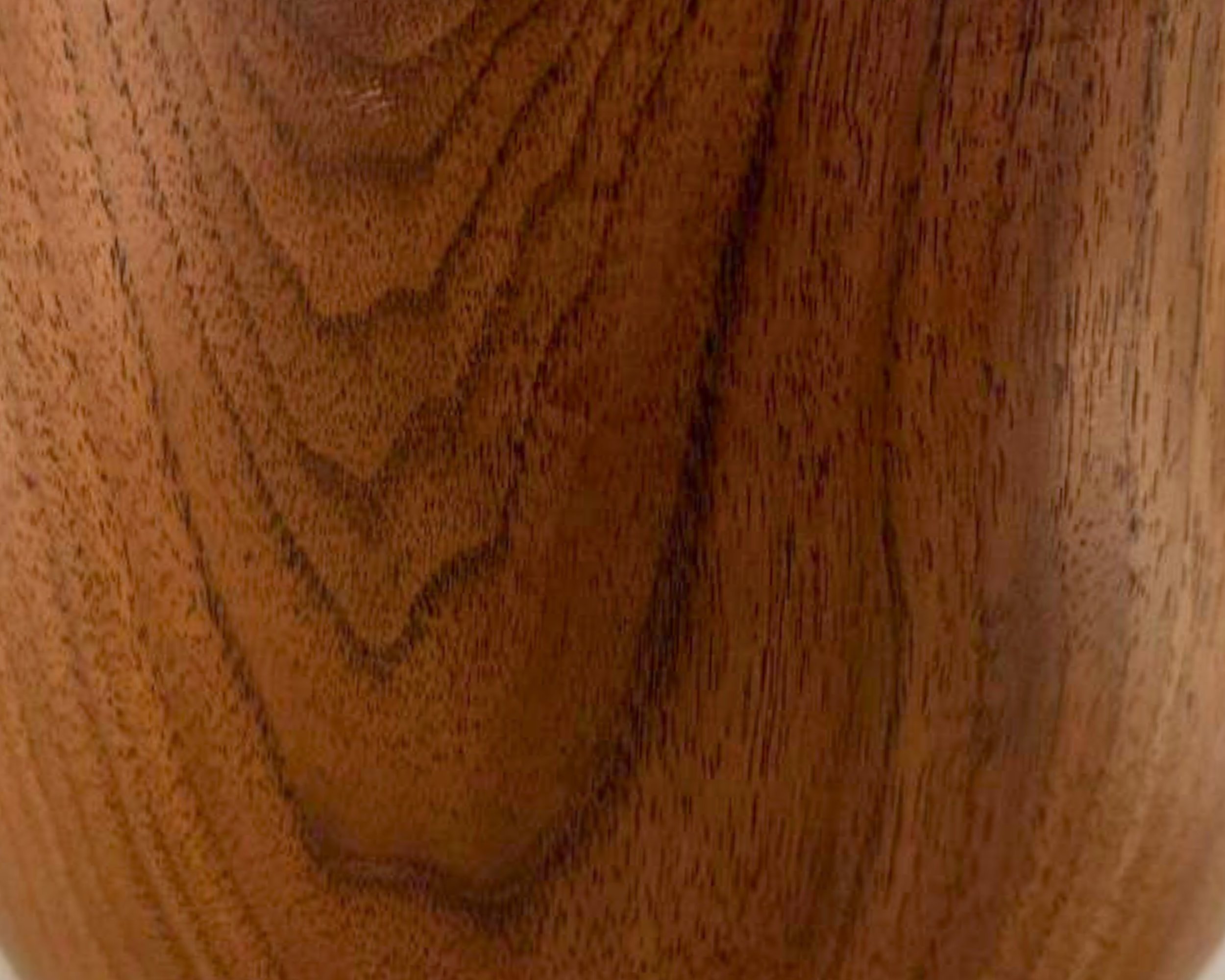 Close-up of walnut grain on the vessel body, showing flowing bands and tonal variation under a satin finish.