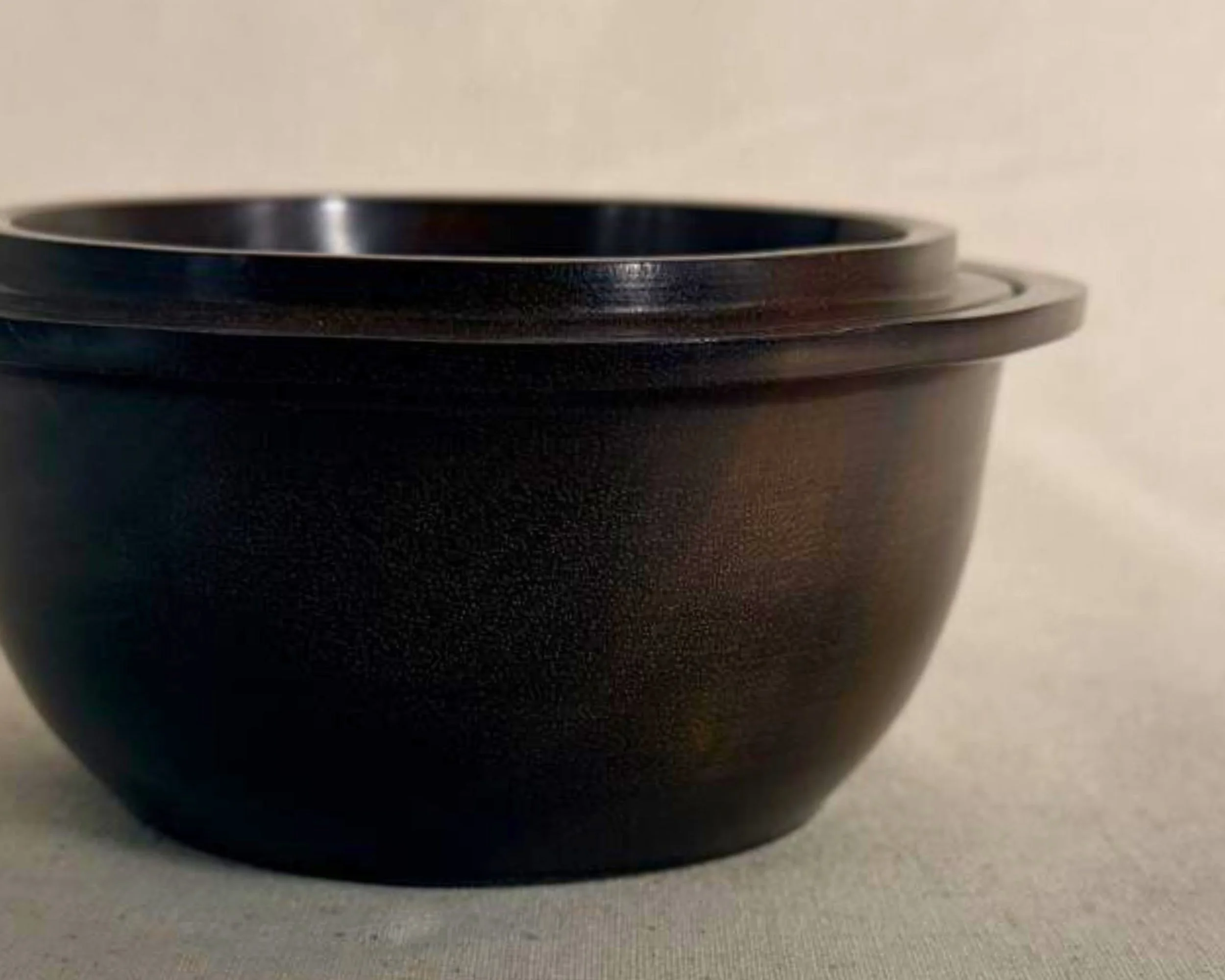 Side close-up of rosewood bowl showing satin sheen and curved body with flared rim.