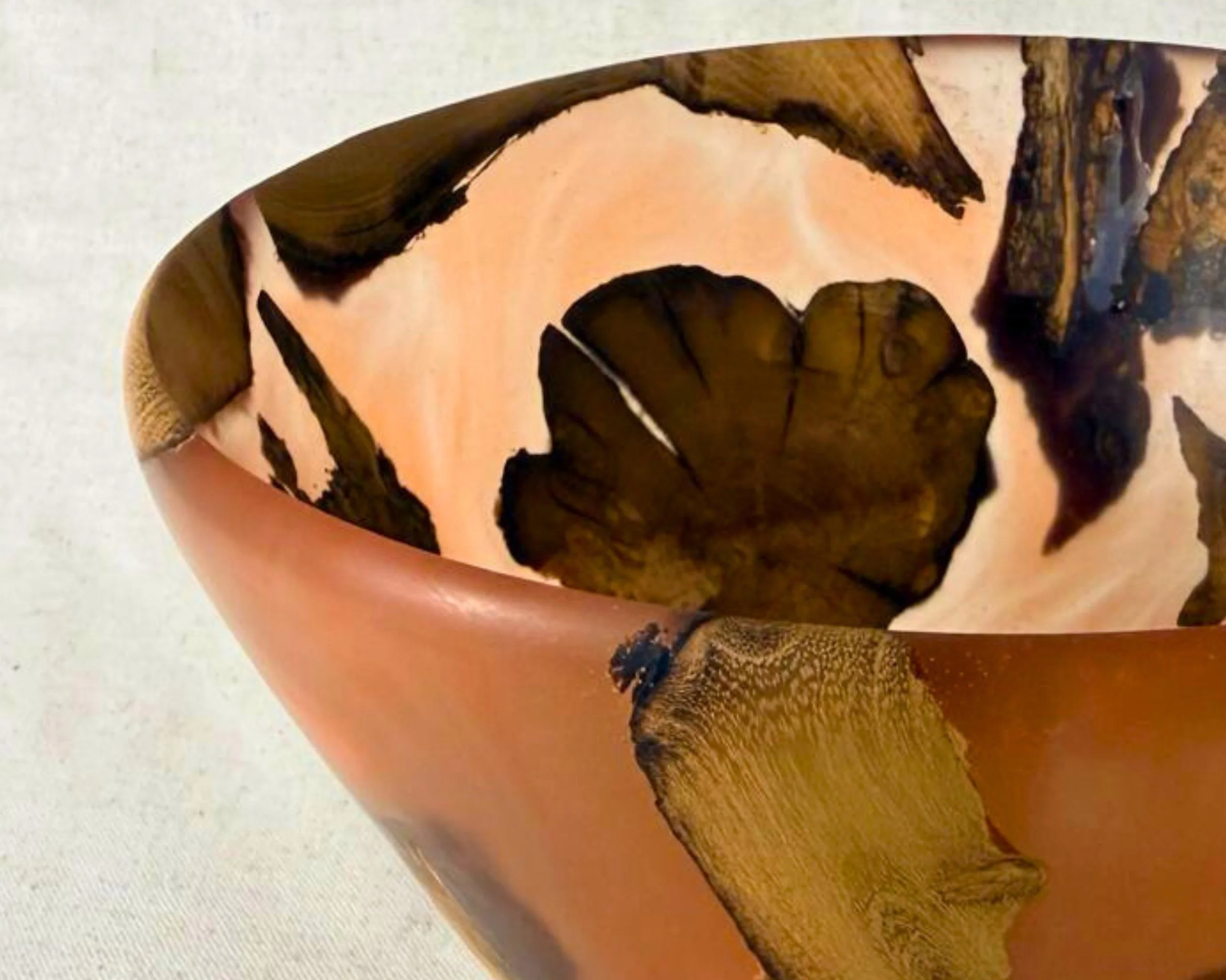 Angled close-up of the rim showing the smooth edge and wood embedded through amber epoxy.